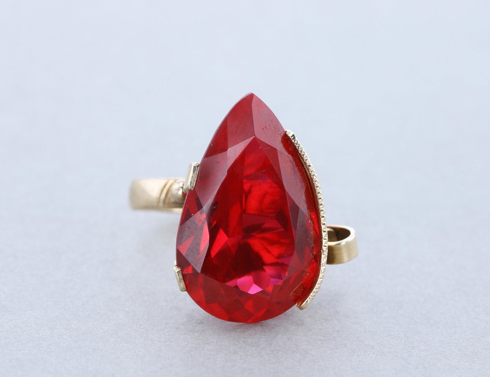 Vintage 14K Large Red Stone Statement Ring: (1) Marked 14K Yellow gold vintage large 28.6x16.8mm Syn. Ruby red pear shape stone ring. 8.7dwt. Sz.9