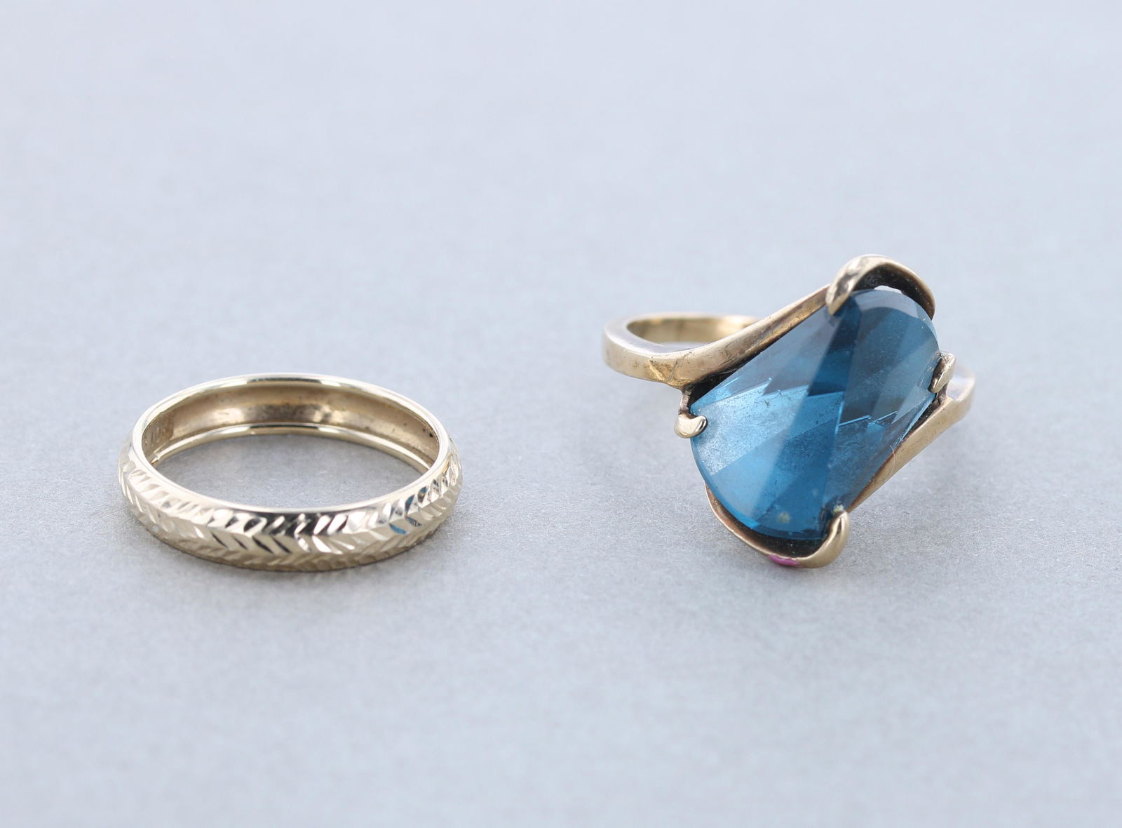 (2) 10K Gold Rings: (2) 10K Gold Ring lot C/O; (1) 10K Yellow gold blue topaz ring sz. 9.5; and (1) 10K Diamond Cut finish, Sz. 7 Total weight: 4.5dwt.
