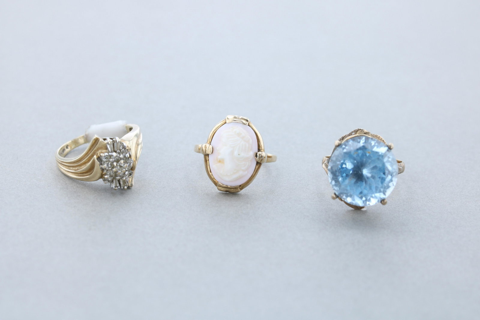 (3) 10K Yellow Gold Cocktail Rings: (3) 10K yellow gold cocktail rings; (1) unmarked 10K blue 16.2mm stone vintage ring sz. 9, (1) unsigned 10K, 14.4mm oval cameo ring Sz: 8 (1) marked 10K yellow gold diamond cocktail ring set with 11 2