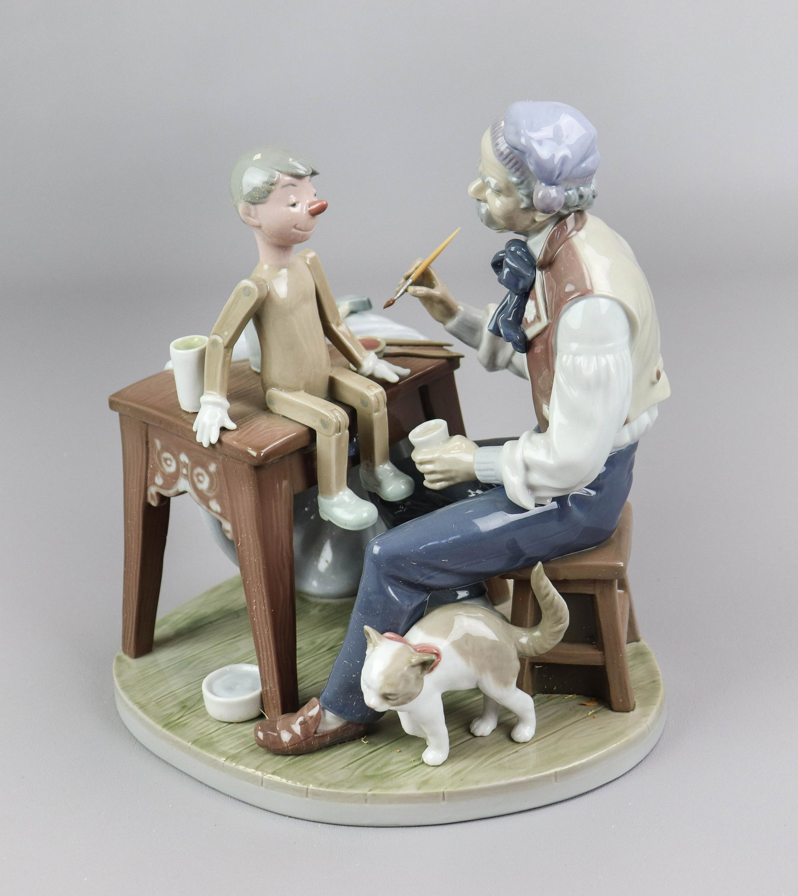 Lladro Decorating Pinocchio Figure: Lladro porcelain figurine, " decorating Pinocchio", depicting Gepetto painting puppet, No 5396, 9-1/4" h, with original box, underglaze, in manufacture cannot be felt with finger