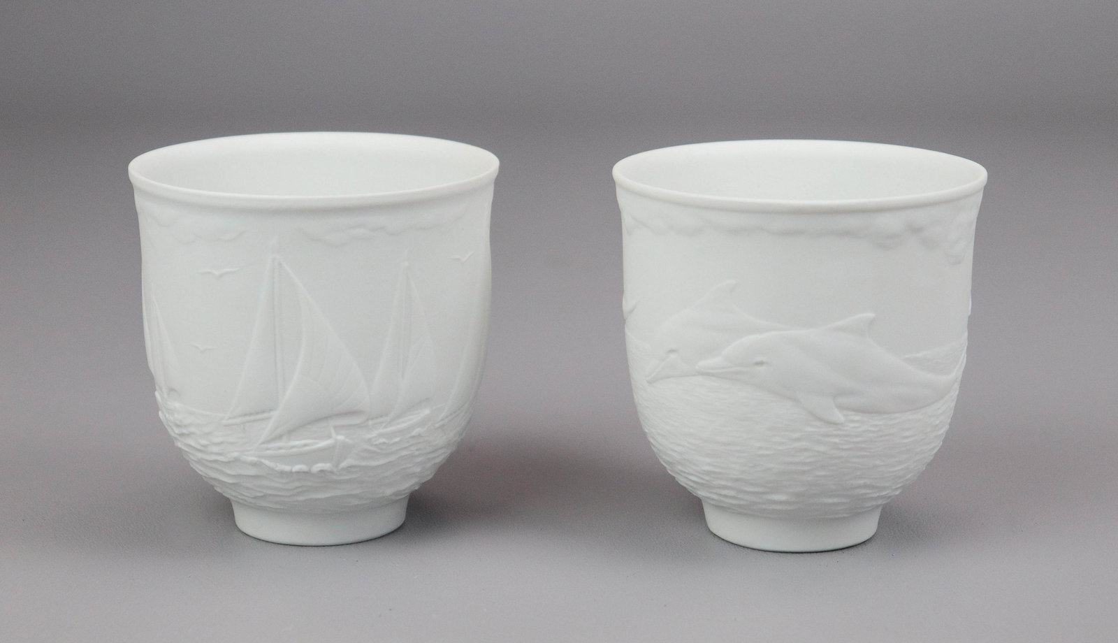 (2) Lladro Collector Society Cups: (2) Lladro Collector Society porcelain cups, c/o "Sailing the Seas" No 17657, " dolphins at Play" No 17658, 3-1/4" h, with original boxes