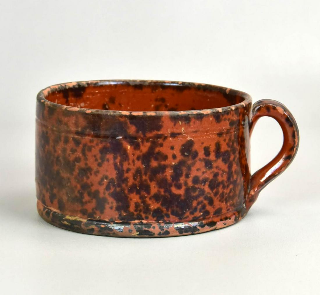Large Manganese Splotch Decorated Redware Mug: Large manganese splotch decorated redware mug, 5-1/2" diam x 2" h, with usually expected glaze flake and wear.