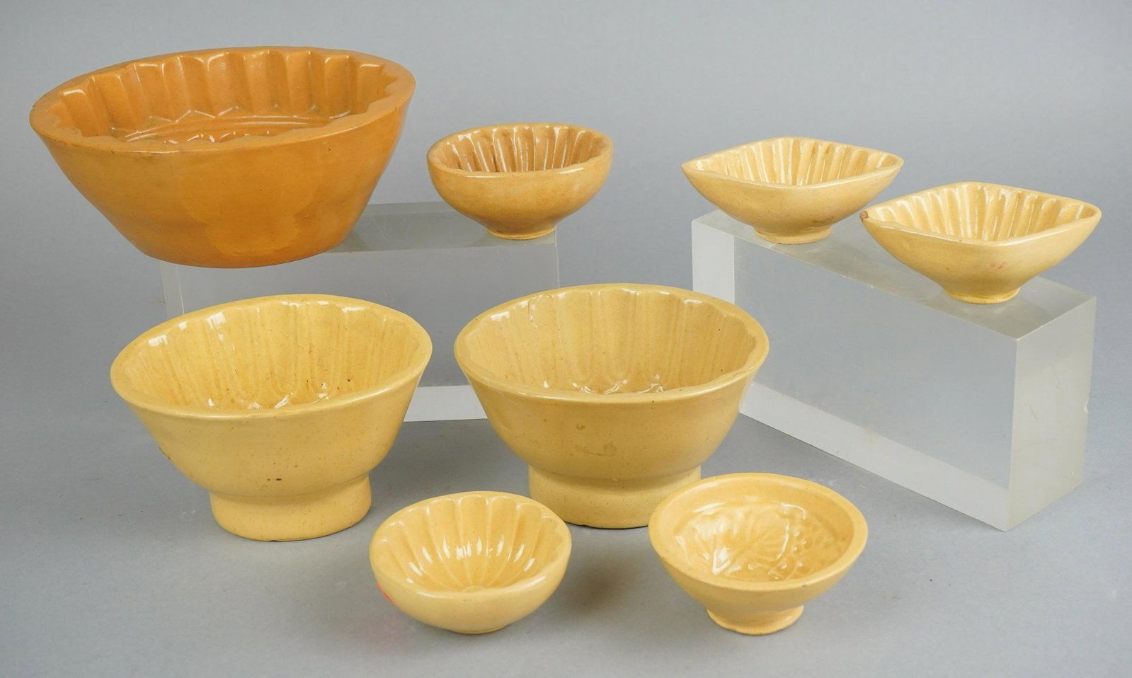 (8) Yellowware Butter Molds: (8) Yellowware butter molds in fruit, leaf and texture decoration, largest 6-1/2"x5", smallest 3" dia