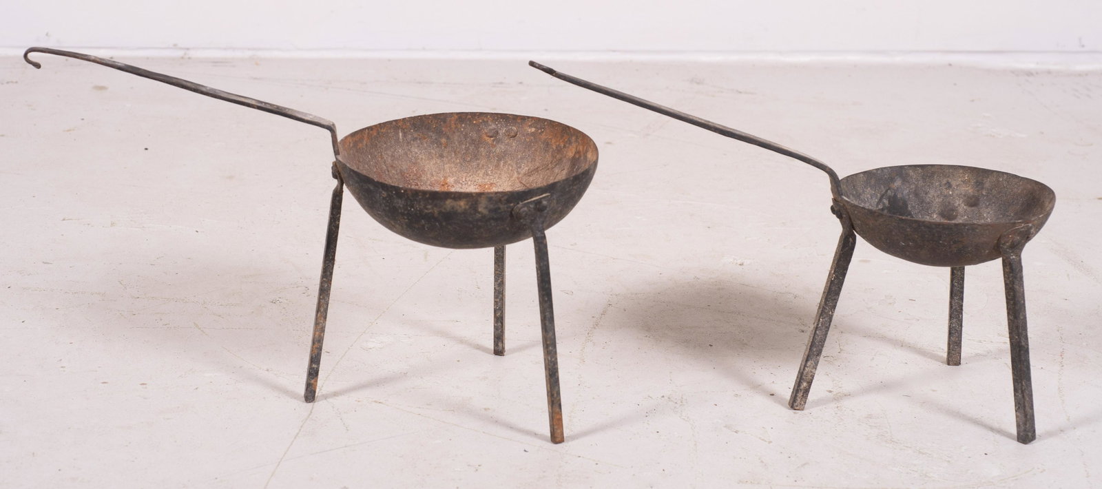 (2) Cast Iron Spider Pans: (2) Cast iron spider pans, tri foot base with elongated handle, 6-3/4" dia and 7-3/4" diam