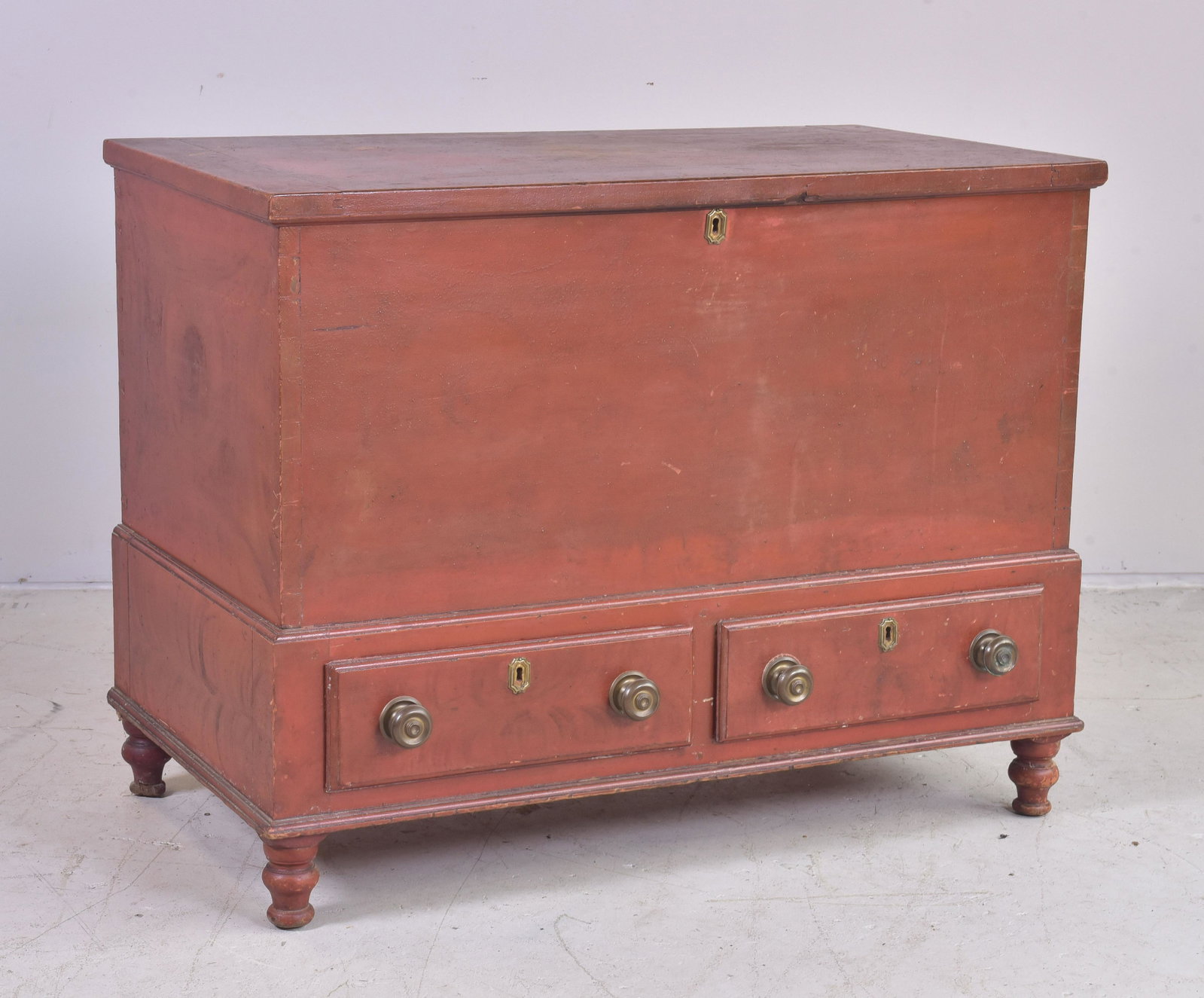 Red and black painted dovetailed blanket chest: Red and black painted dovetailed blanket chest, interior with small drawers, base with two drawers, raised on two legs, 29"h x 37-1/4"w, wear consistent with age