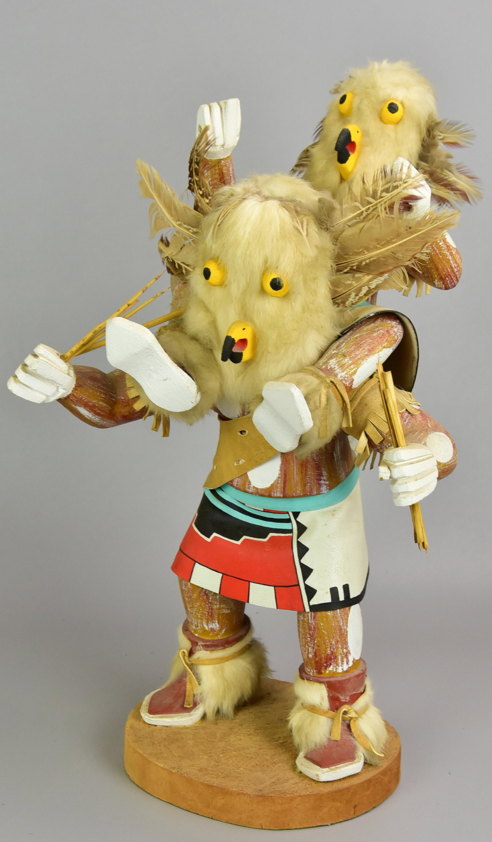 White Owl Kachina Doll: White Owl kachina doll in painted leather dress with fur trimmed boots, downy decorated head and rider on shoulders, sticks clutched in both hands, on wood plinth with underside reading 'White Owl, Wi
