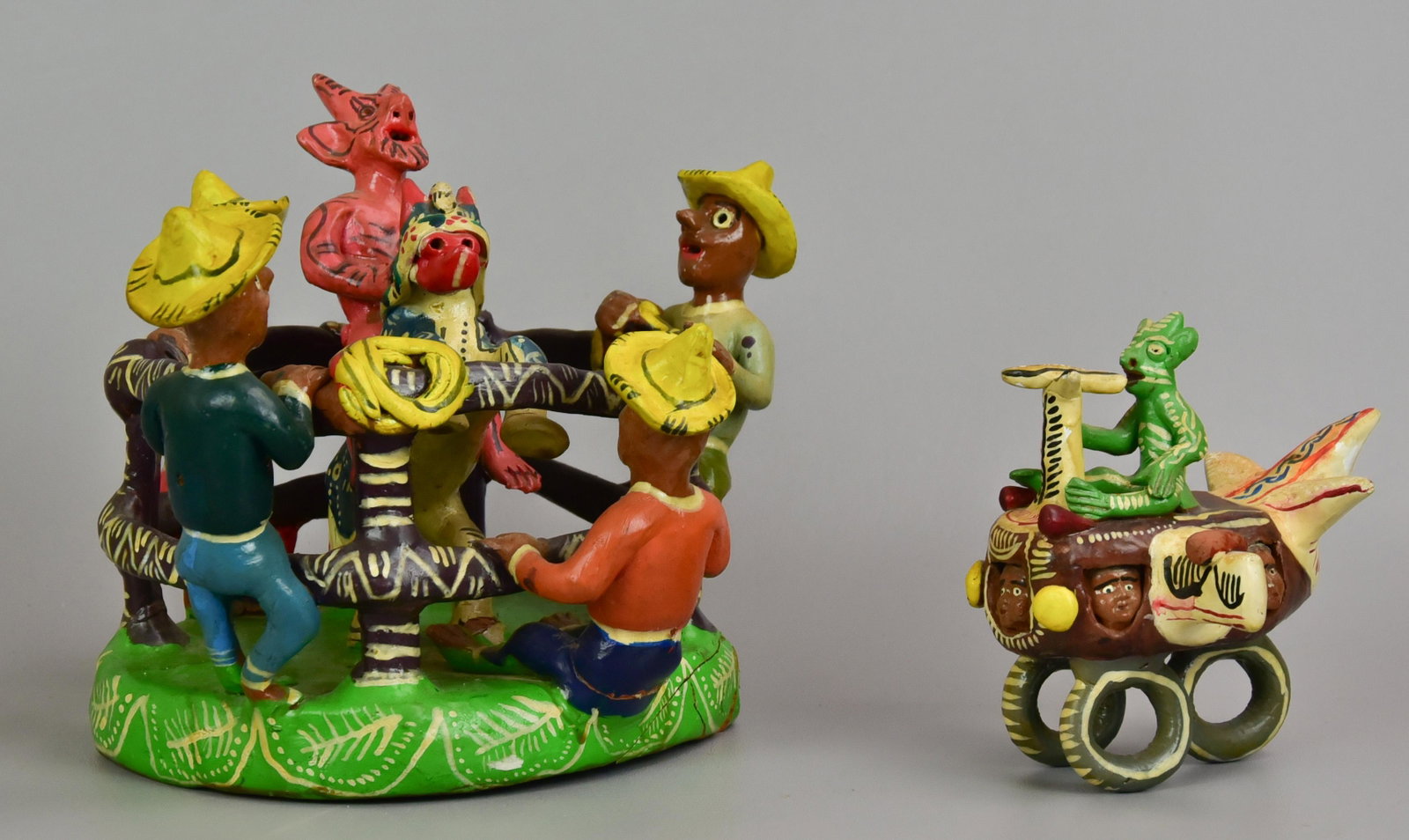 (2) Mexican Folk Art Sculptures: (2) Mexican folk art sculptures to include airplane manned by devil pilot and horse riding devil in fenced area with awed cowboy surround, 9-1/2" diam x 8" h, some repairs.