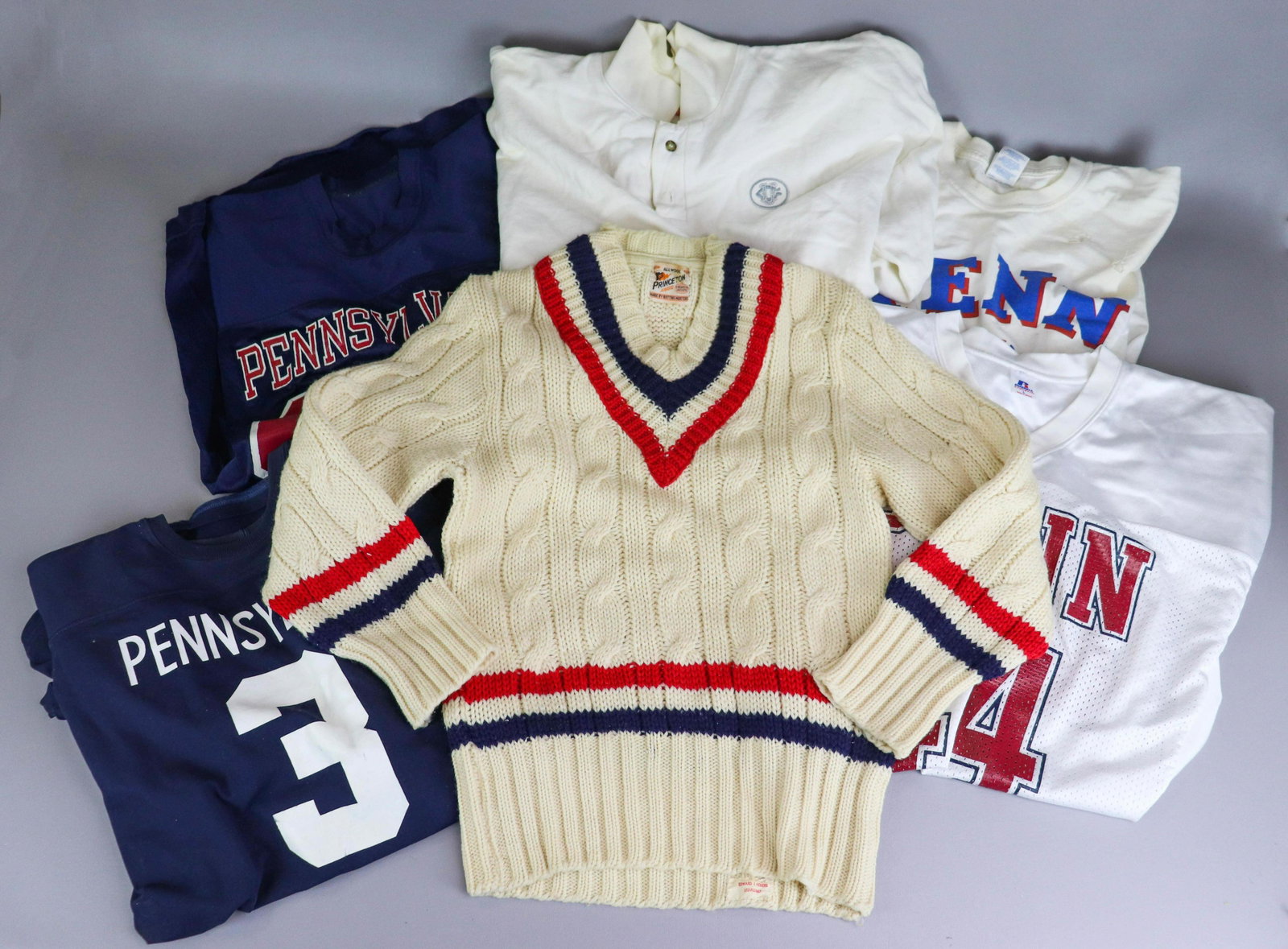 Penn and University Garments and Jerseys: Penn and University garments and jerseys to include Princeton Award brand v-neck sweater, 34" bust, poor condition Penn t-shirt, holes, Pennsylvania University '84' jersey in navy and maroon, Champion