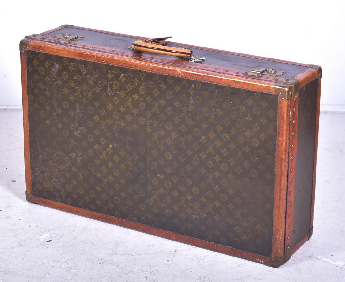 Mid 20th c. Louis Vuitton Hardside Suitcase: Mid 20th c. Louis Vuitton hardside suitcase, 31-1/2"L x 19"H x 8-1/2" D, in partial classic stamped monogram, with top and single side with monogram significantly lighter, and tacked leather trim surr