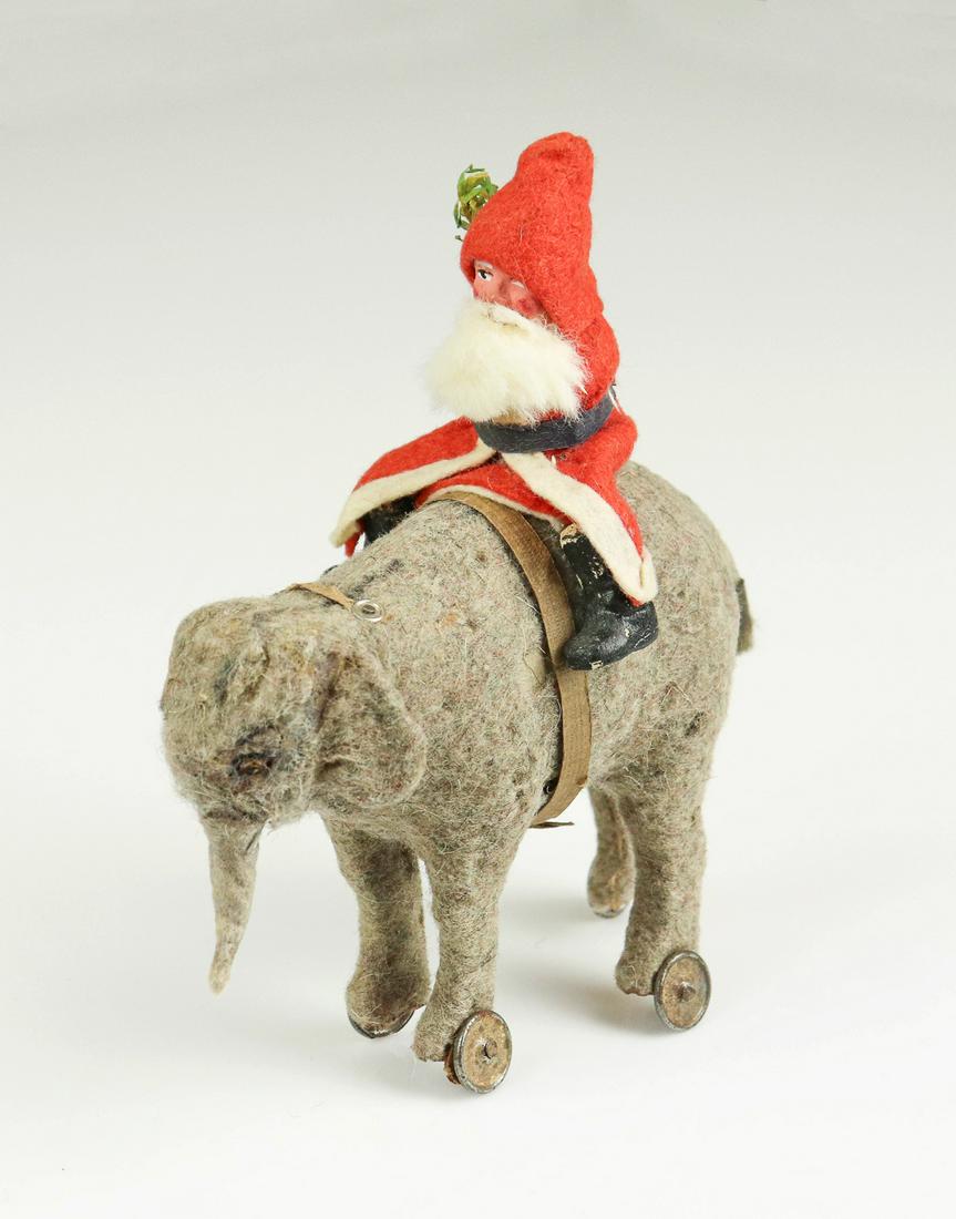 1920's Santa on Felted Elephant Pull Toy: 1920's Santa on felted elephant pull toy, German, includes cross arm Santa in felted robe and hat with fur beard, painted face and boots and sprig behind ear, perched atop felted wool covered cardboar
