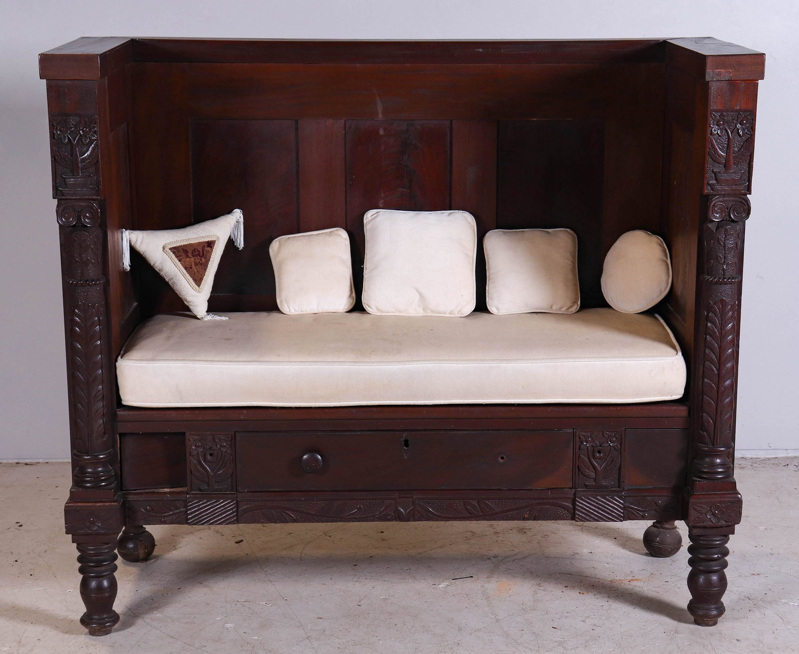 Carved mahogany Federal Revival hall bench: Carved mahogany Federal Revival hall bench with paneled back and high ends, carved and turned half spindles, centering a lower drawer, all raised on turned legs, late 19th c, 54"w x 46-1/2"h x 21-1/2"