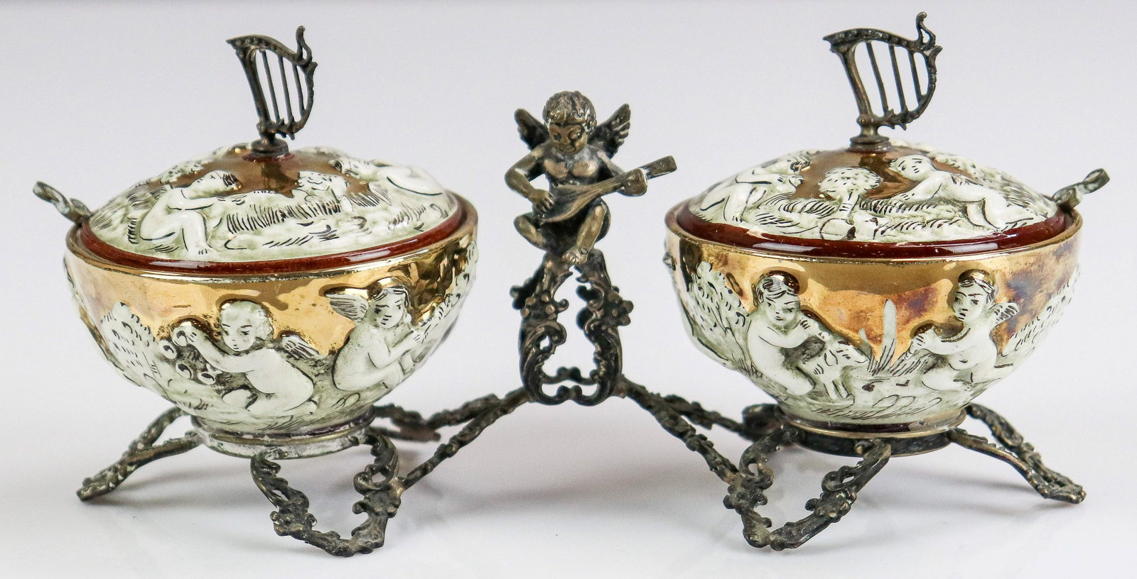 800 Silver Framed Porcelain Condiment Set: 800 Silver framed double condiment set, cherub with lute center, embossed porcelain bowls with lyre finials & treble clef spoons, 6-2/3" h x 3" h