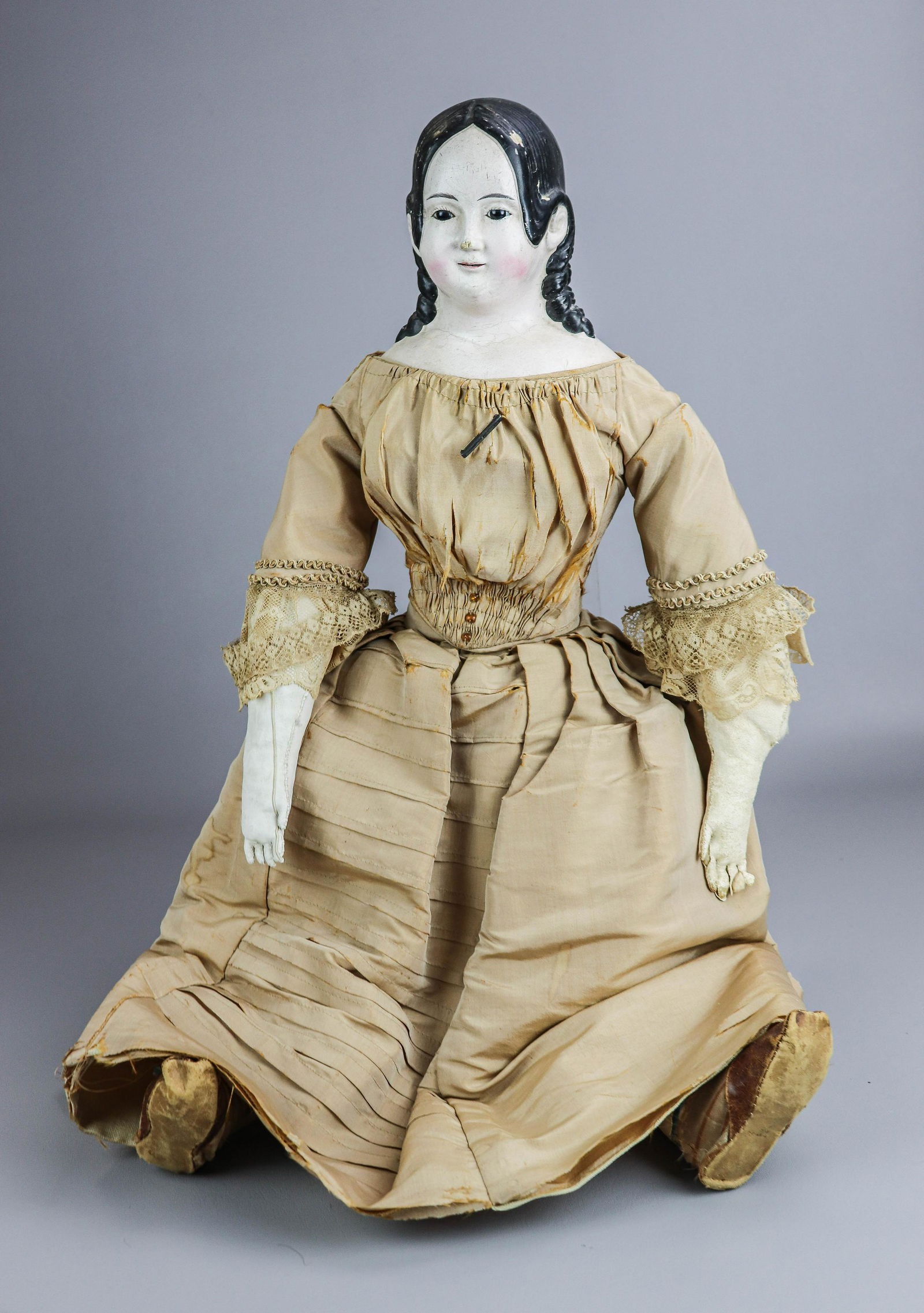 Molded Hair Papier Mache Doll: Molded hair papier mache doll, papier mache shoulders, leather arms and soft body, with glass eyes, painted eyebrows and parted open mouth, wearing period correct silk and lace gown and leather shoes,