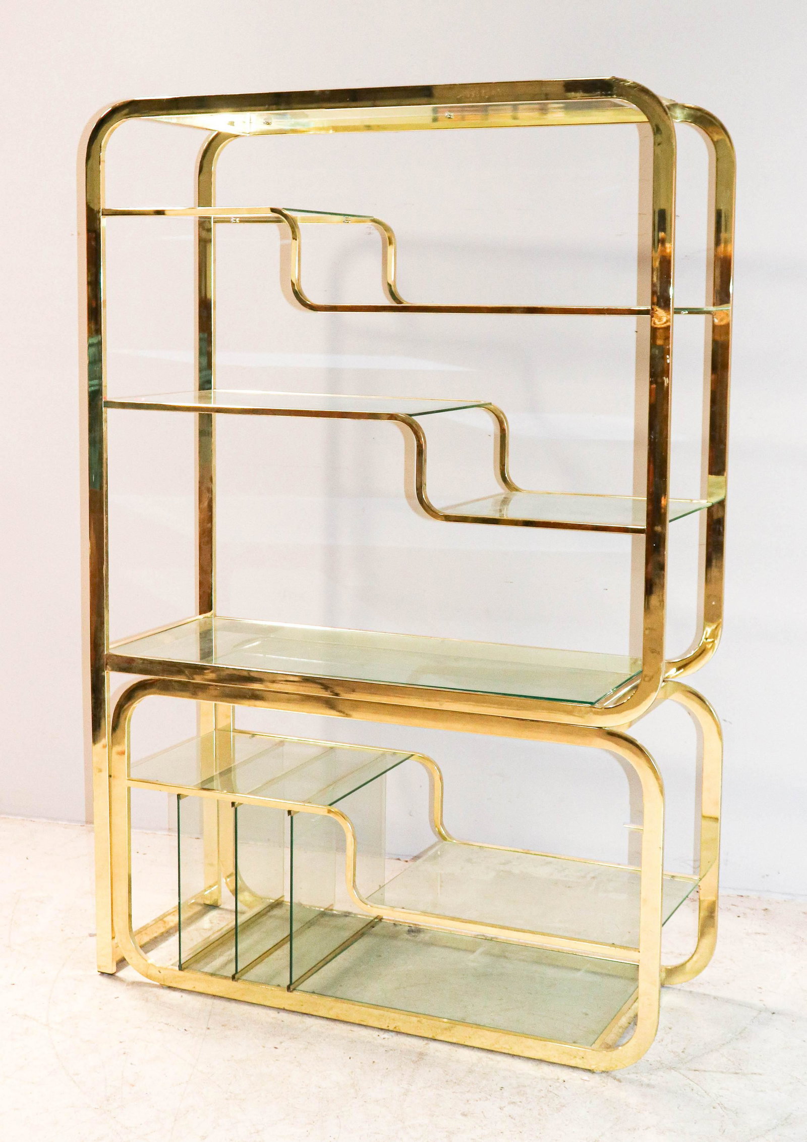 Milo Baughman for DIA brass and glass etagere: Milo Baughman for DIA brass and glass etagere, brass frame with glass shelves, base with magazine rack at one end, 72Ã¯Â¿½h X 48Ã¯Â¿½w X 18Ã¯Â¿½d