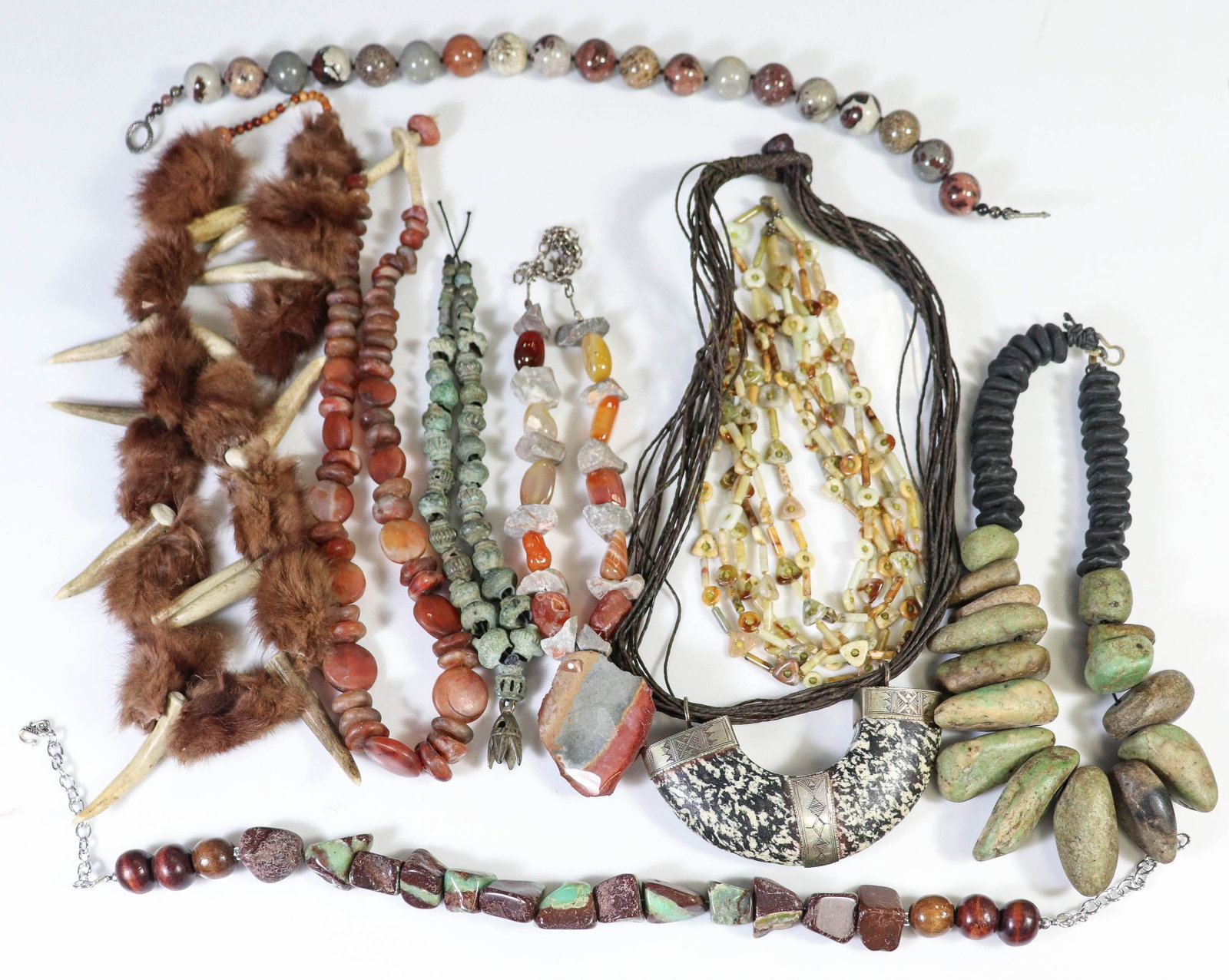 (9) Pc Lot Of Carved Stone Necklaces: (9) Pc Lot of Stone Necklaces Lot C/O: (1) Antique metal bead necklace, (1) Carved tooth necklace, and (7) stone handmade necklaces.