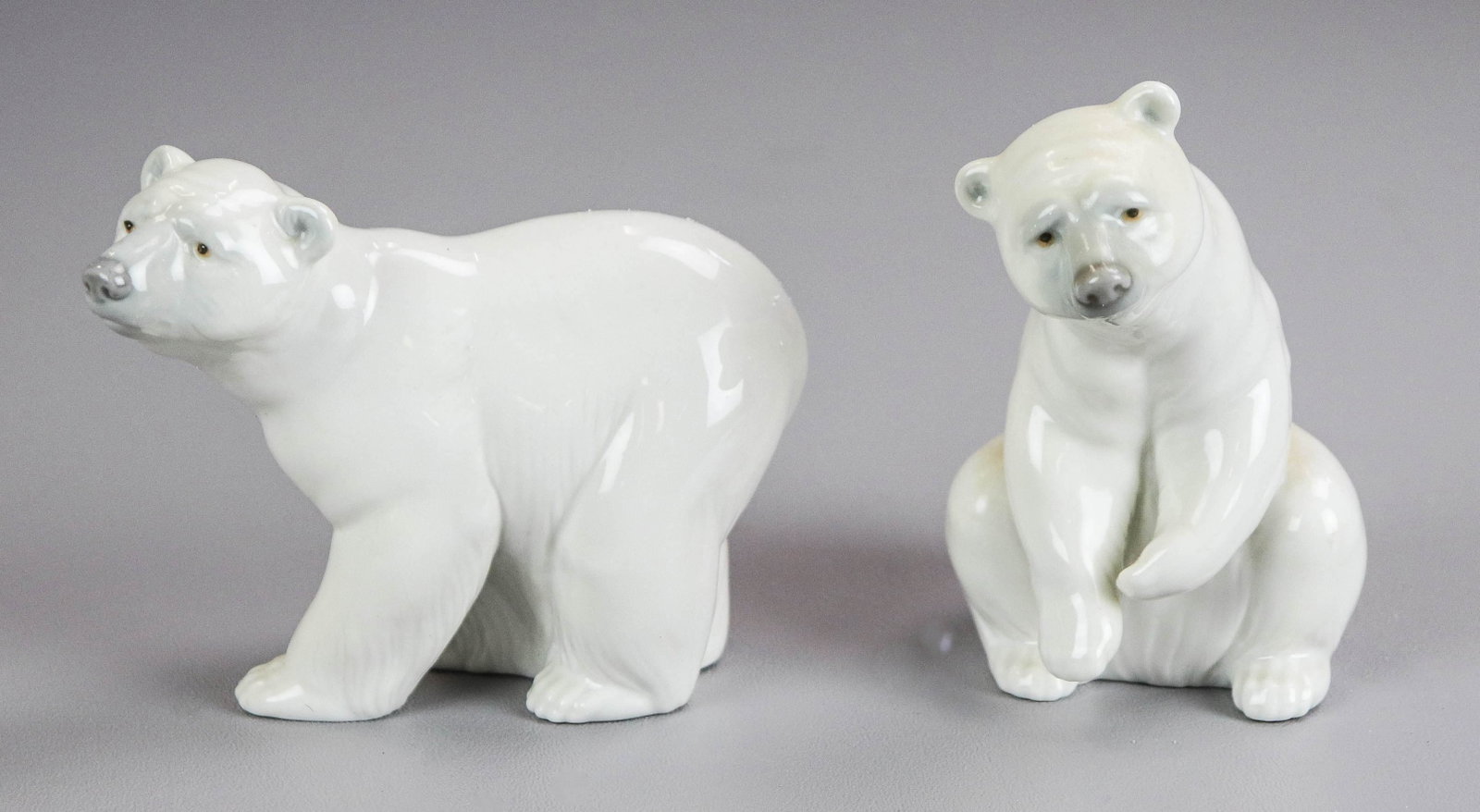 Pair Porcelain Lladro Polar Bear Figures: Pair porcelain Lladro polar bear figures, seated, 4-1/2" h and bear in mid stride looking upward, 5" L