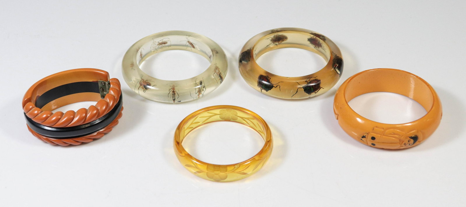 (5) Bakelite Acrylic Resin Bangles: (5) Bakelite Acrylic Bangles; two have insects embedded in resin. Wear to paint on harlequin, hinge neither too tight nor too loose. Minor rough spot on edge of engraved floral bracelet, possibly in m