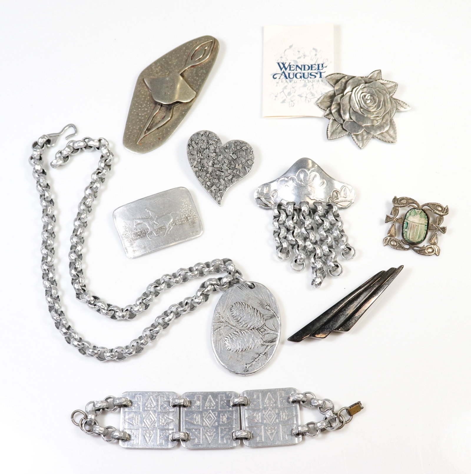 (9) Pc Aluminum Wendell August Jewelry and Other: (9) Pc Aluminum Wendell August Jewelry and Other; Lot includes (4) signed brooches, (1) silvertone modern ballerina pin, (1) Aluminum panel bracelet, 8" (1) 22" necklace, (1) silver scarab beetle pin,