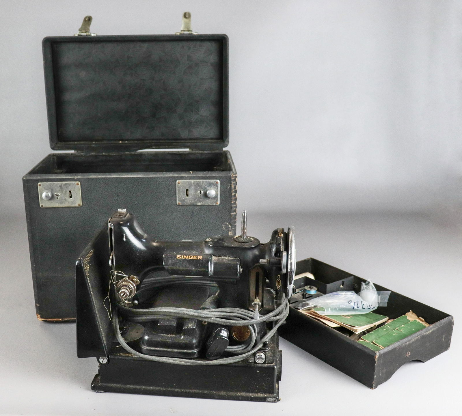 Singer Sewing Machine 221-1 Featherweight: Singer sewing machine 221-1 featherweight in original case, bobbin case in tact, with original owners manual and assorted extras incl. bobbins and machine needles. Motor runs, needle goes up and down