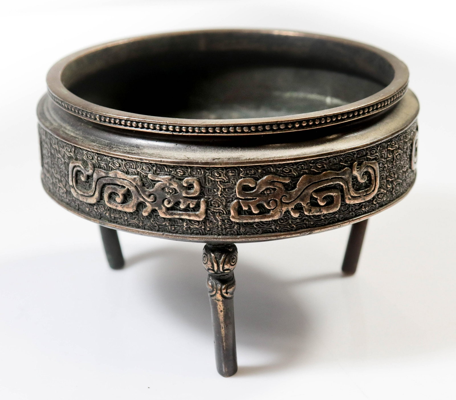 Bronze Asian Censer: Bronze Asian censer, tri-footed with dragon and cloud embossed surround, 6-character mark to underside, (1) leg replaced, 5" diam, 3-1/2" H