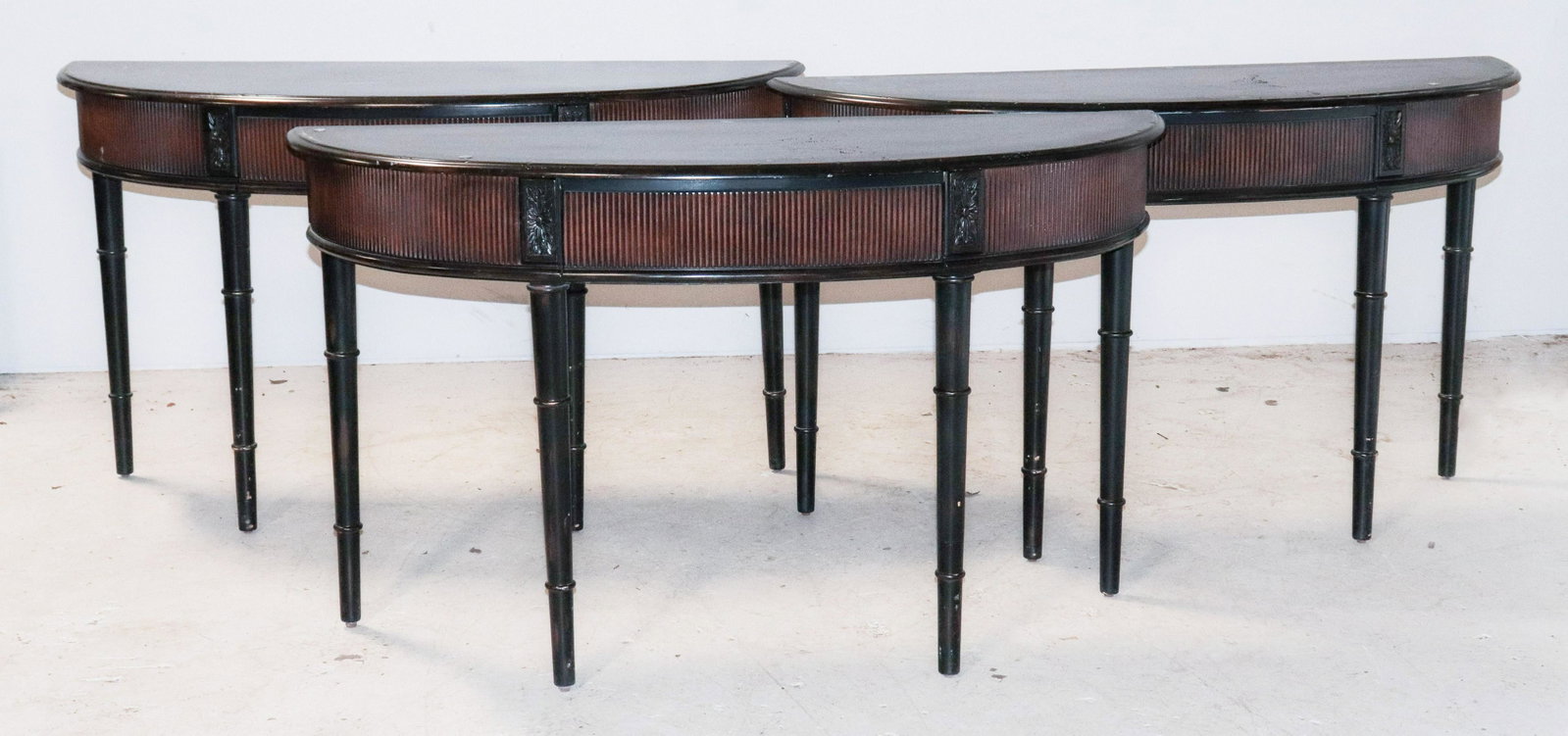 (3) Ebonized Regency style demilune consoles: (3) Ebonized Regency style demilune consoles, rosettes at end, faux bamboo legs, 32-1/2"h x 57"w
