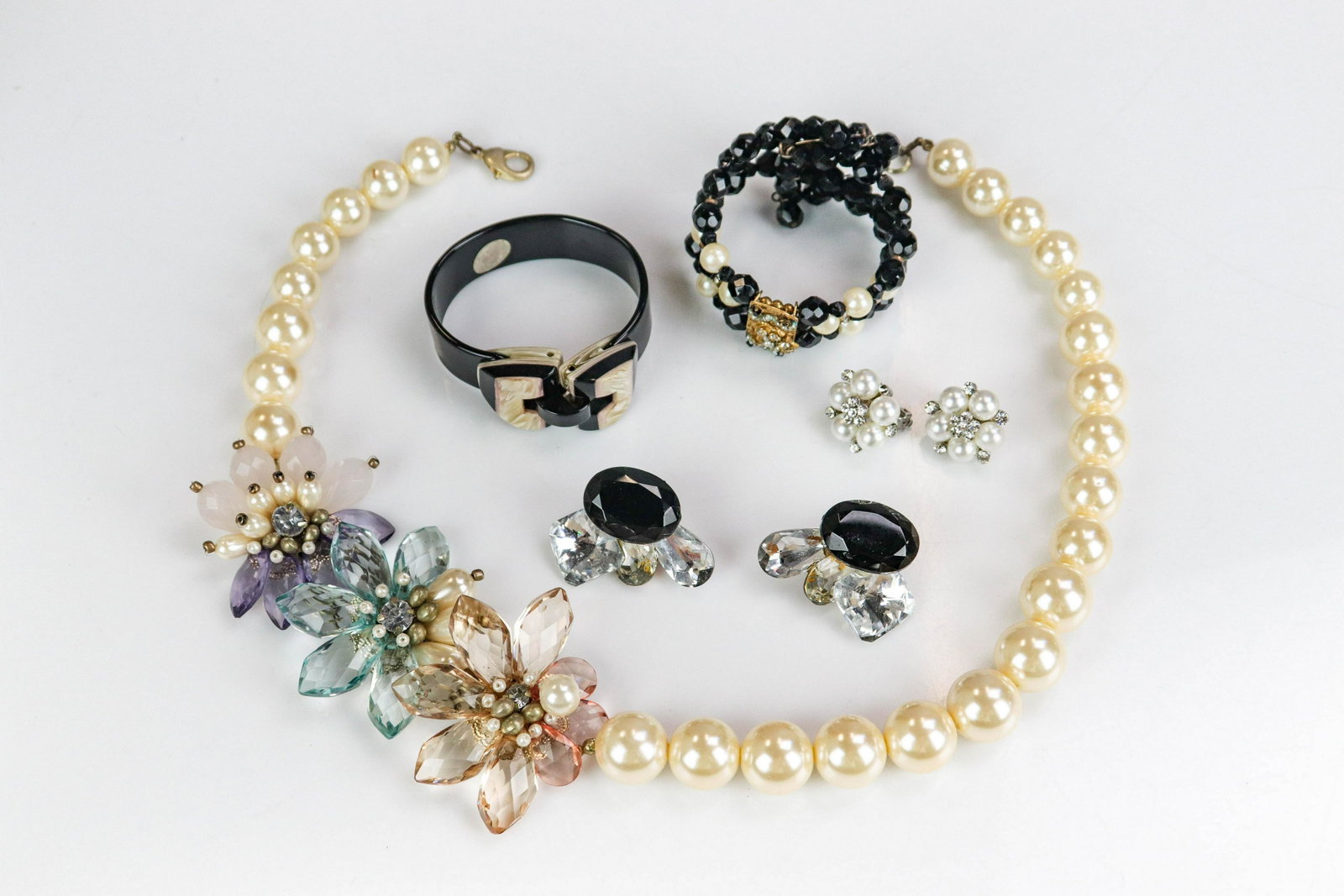 (5) Pc Vintage Jewelry Lot: (5) Pc Vintage jewelry lot; C/O: (1) fashion large faux pearl bead necklace, (1) pair of 1960' clip on glass earrings, (1) Black Bakelite bangle, (1) pair of clip on faux pearl and rhinestone earrings