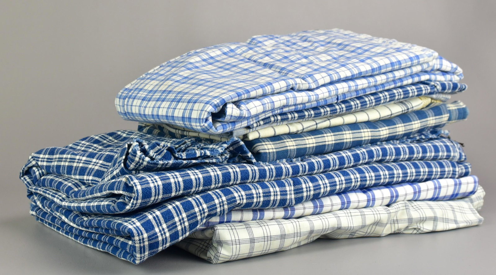Grouping of Early Homespun Fabric and Bedcovers: Grouping of early homespun fabric and bedcovers to include 62-1/2" x 49" coverlet, some staining, 46" x 26" pieced portion of blue check fabric, 31" x 28-1/2" blue check pillow case or crib quilt cove
