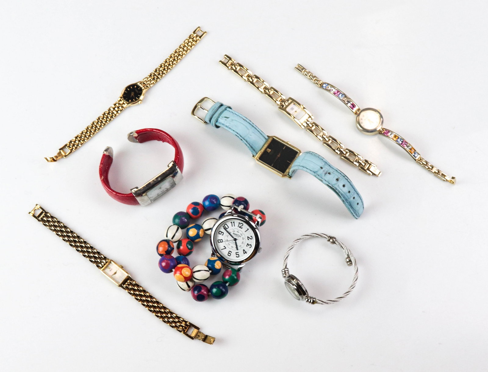 (8) Ladies Watches: (8) Ladies Watches lot C/O; (1) gold tone seiko; (1) gold tone ESQ; (1) gold tone Caravelle; (1) Geneva fashion watch, (1) Trendz quartz watch, (1) red cuff bracelet, (1) Seiko watch with light blue b