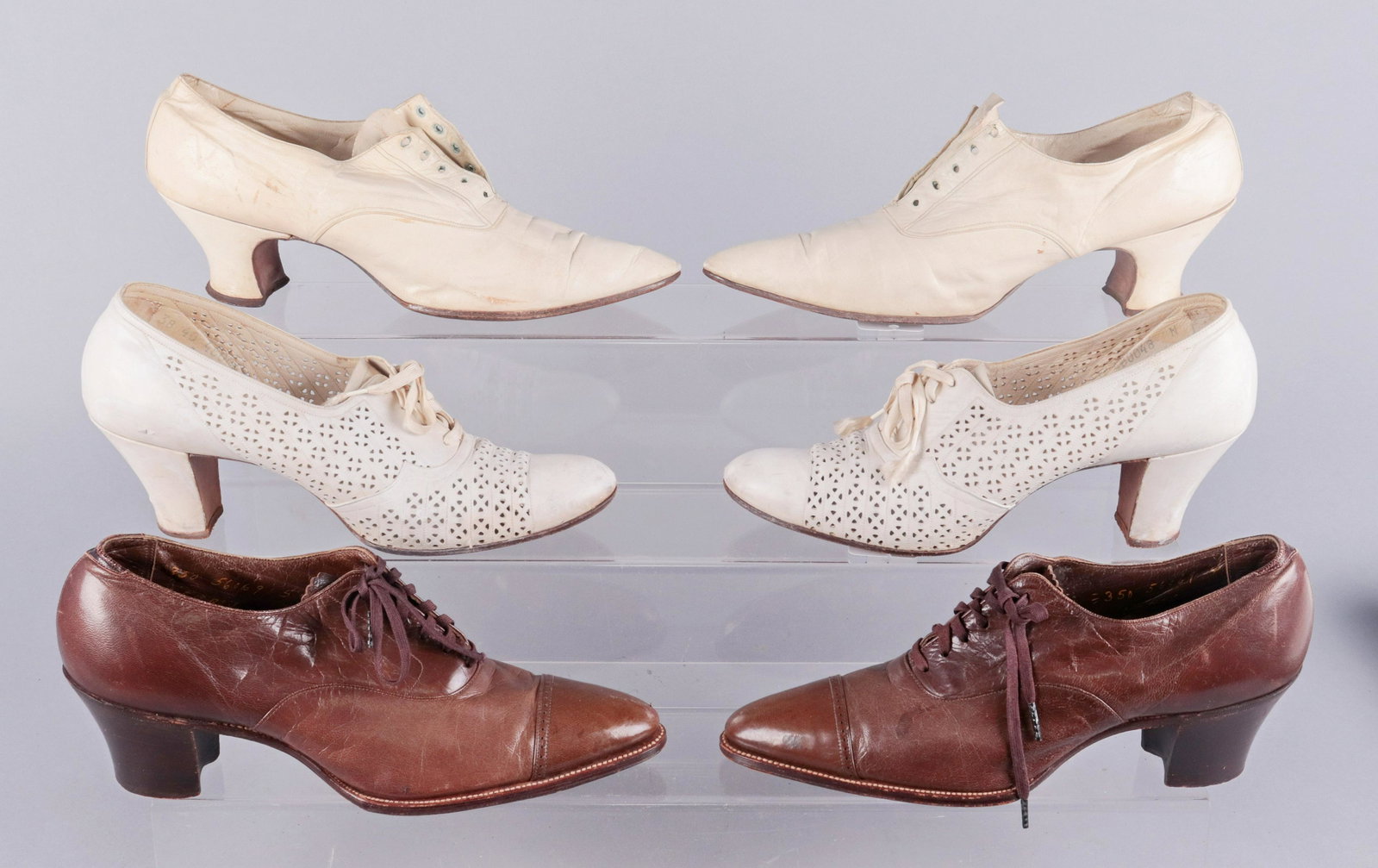 (3) Pair Early 20th c. Shoes: (3) Pair early 20th c. shoes to include early 1900's cream kid skin louis heel lace up bootie with pointed toe, 10" heel to toe, narrow width, 1910's brown leather oxford with brown leather stacked cu