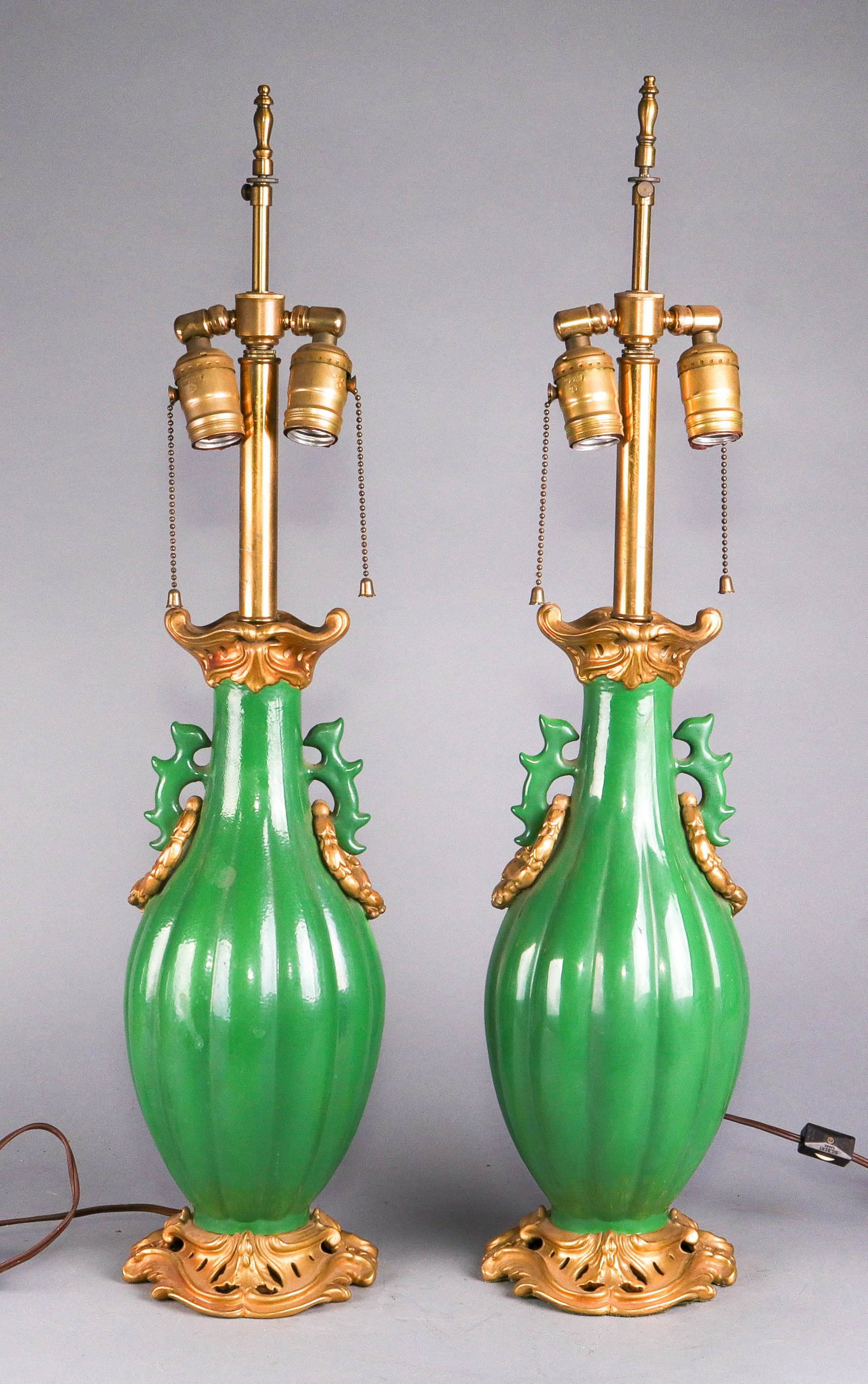 Mottahedeh Porcelain Lamp Pair: Mottahedeh porcelain lamp pair c/o green elongated melon form bodied lamps with double handles at neck in Asian taste with gilt gold wreath loops and pierced gilt gold decoration at neck and foot, dou