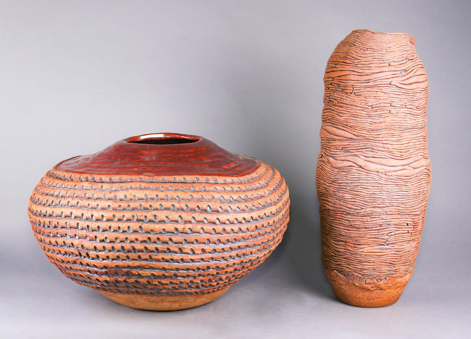 (2) Ida Newman Art Pottery Vessels: (2) Ida Newman art pottery vessels to include 21" h coil pot style vessel and large low coil pot style vessel with textured tic decoration at side and smooth red glazed shoulder, both signed Ida Newma