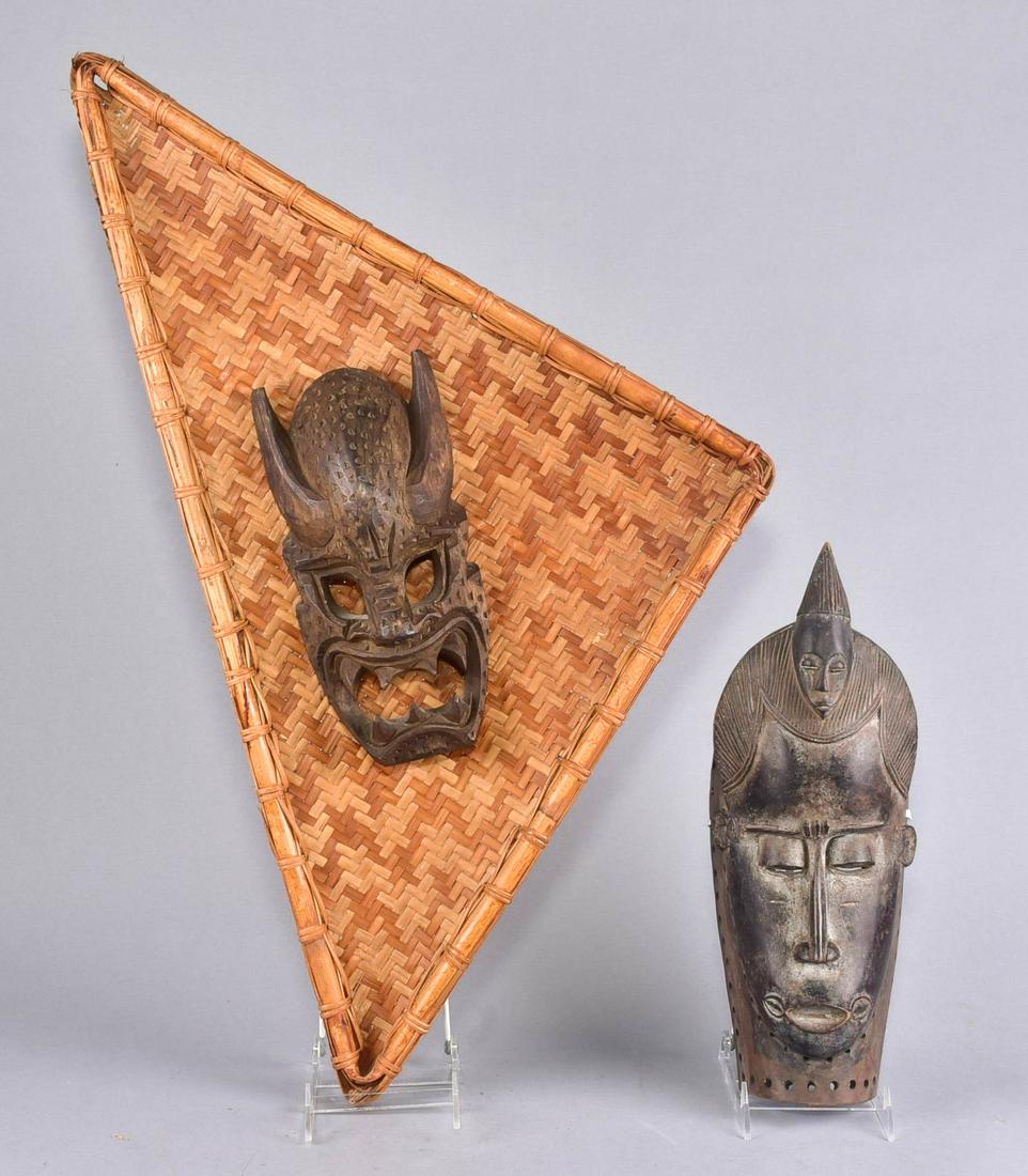 (2) Carved Wood Masks: (2) Carved wood masks, c/o one with horns mounted on rattan basket made in the Philippines (mask 10-1/2" x 4-1/2", 28" x 15" overall), one with pierced border (14-1/2" x 5-1/4")