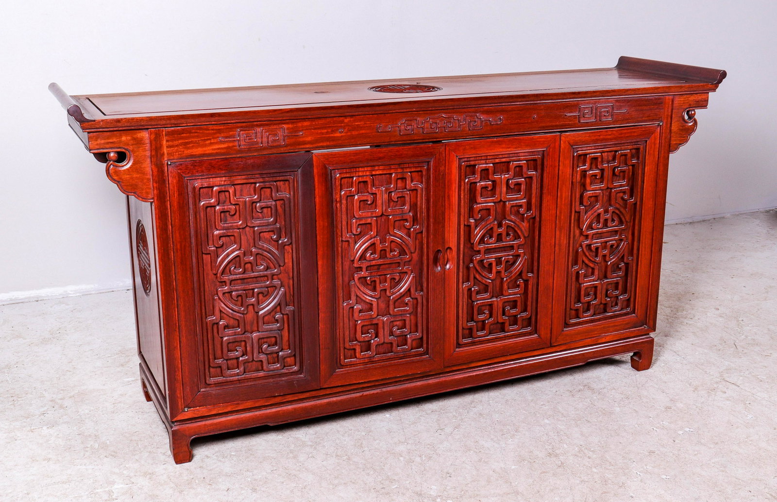 Chinese elmwood buffet: Chinese elmwood buffet, two bifold doors with applied carvings, interior shelving, 35"h x 72"w x 19"d, sun fading to top