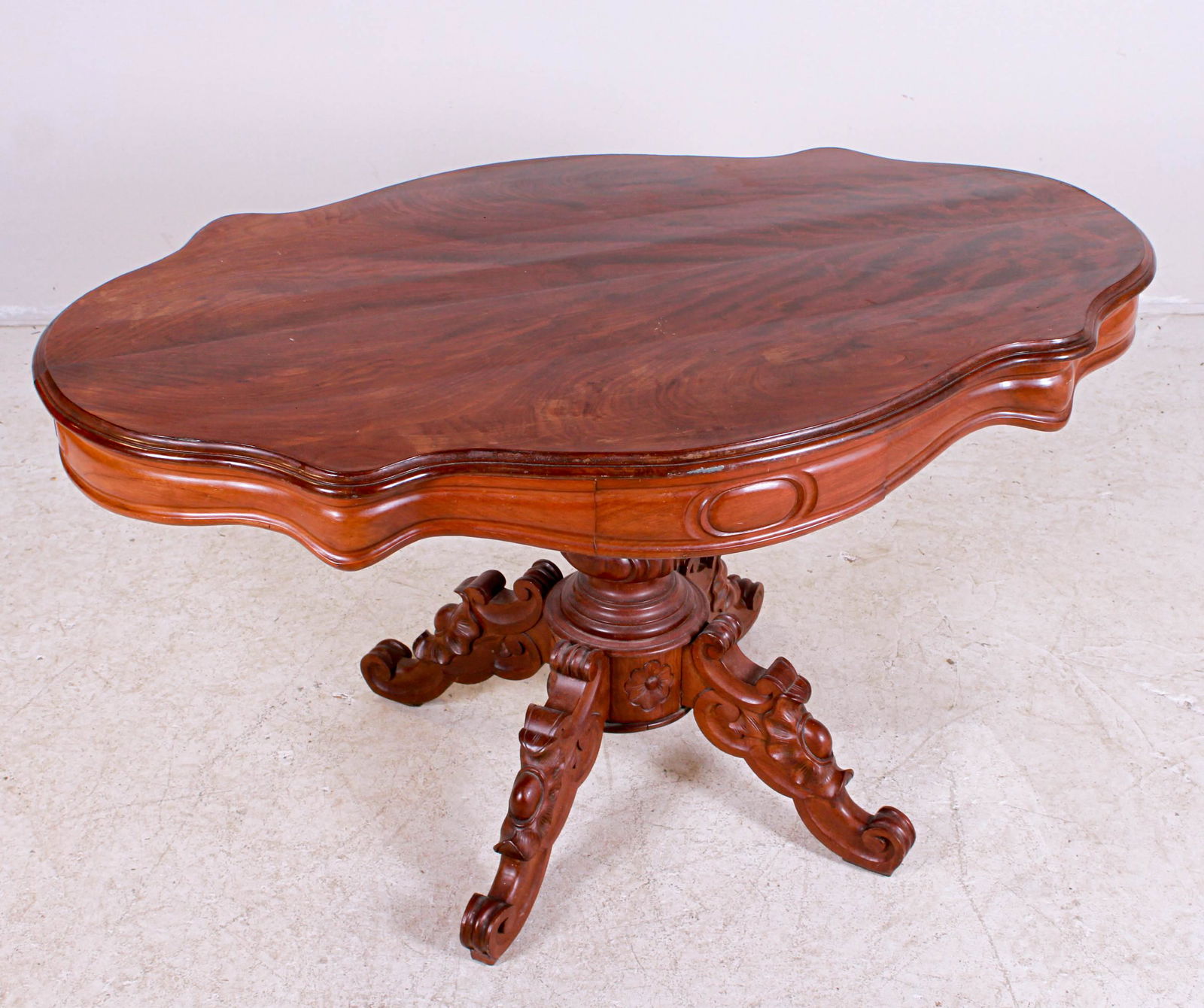 Victorian style carved center table: Mahogany Victorian style carved center table, single drawer, scalloped edge top, pedestal base with acanthus leaf and scrolled feet, 28"h x 51"w x 32"d, damage at left side edge, wear to finish on top