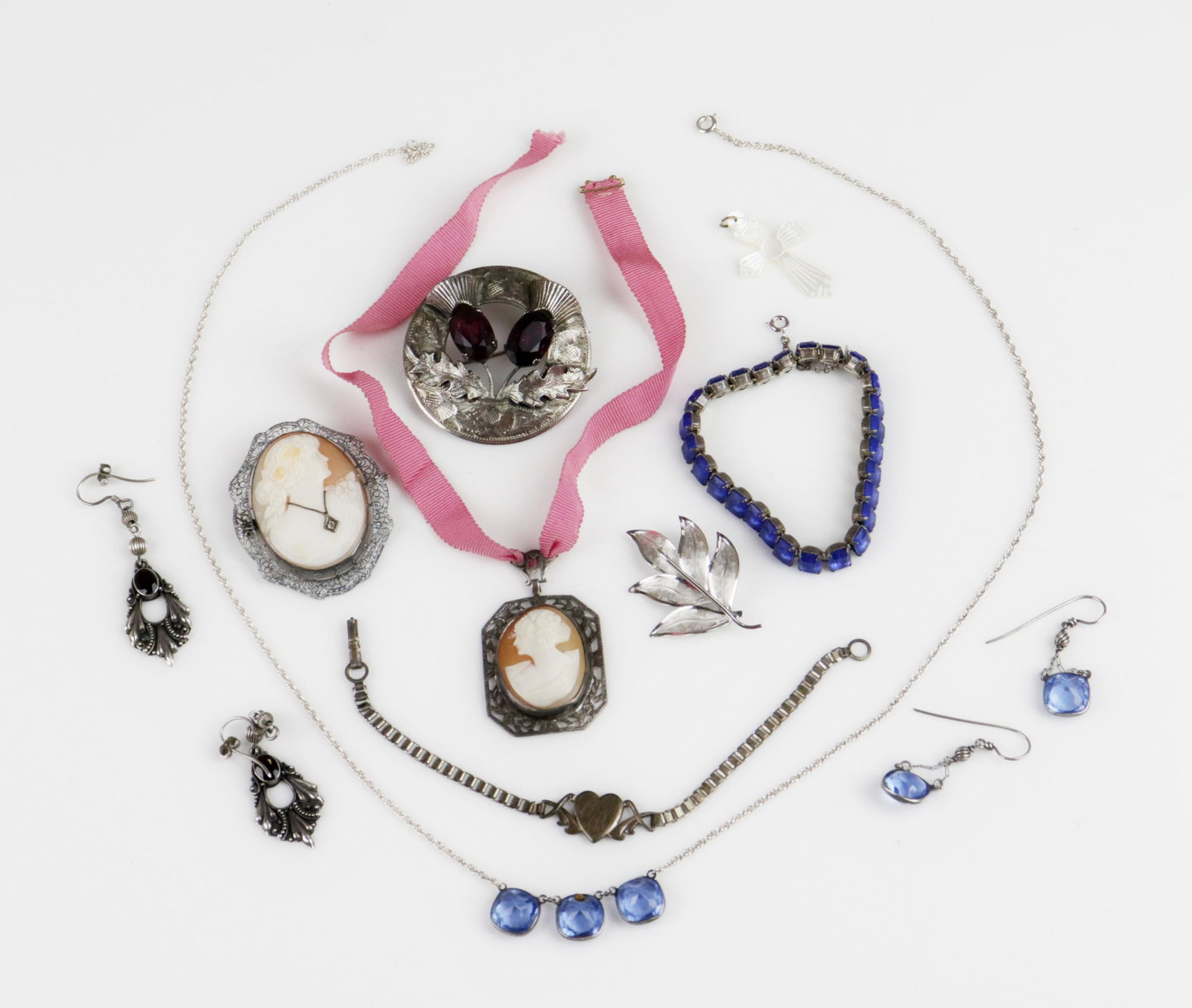 Vintage Sterling Silver Jewelry Lot: Vintage Sterling Silver Jewelry Lot; (1) mother of pearl cross pendant, (1) Sterling leaf pin, 44mm, (1) Large Scottish Thistle round brooch, (1) 7.5" heart bracelet, (1) 7" blue rhinestones, (1) Ster