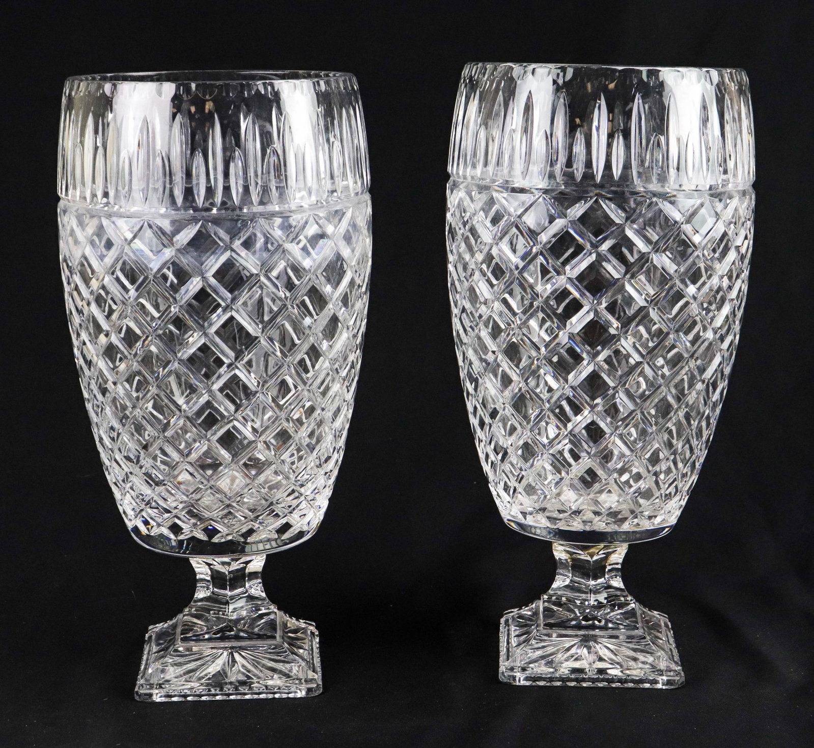 Pair Cut Crystal Footed Vases: Pair cut crystal footed vases, quilt cut on raised square base, 15-3/4" h, after Waterford, unmarked, Scratches at rims, 1 with base re-glued to vessel, needs cleaned, water marks from use.