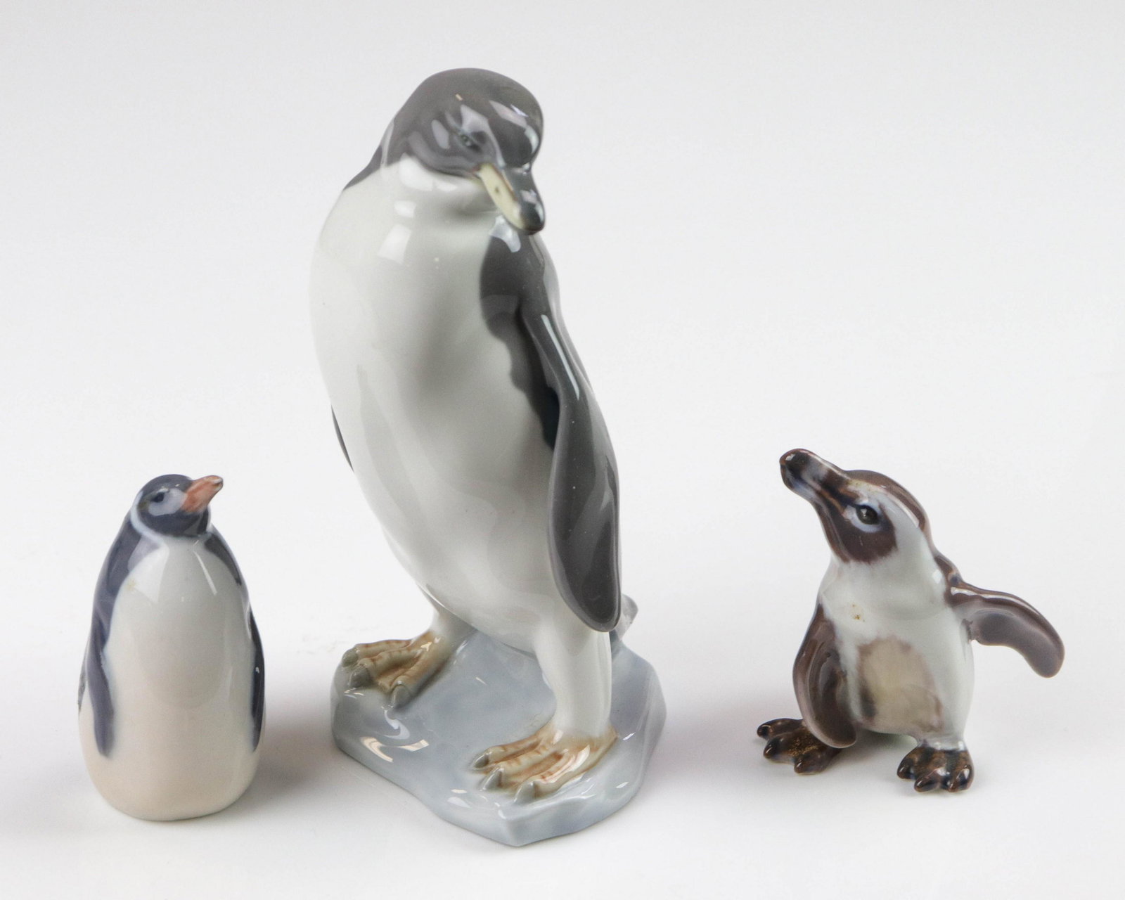 (3) Porcelain Penguin Figures: (3) Porcelain penguin figurines, c/o Lladro E-31 (6" h), Dahl Jensen Copenhagen Denmark (2-3/4" h), Krone og Denmark 3003 c 1923 (3" h), no condition issues noted