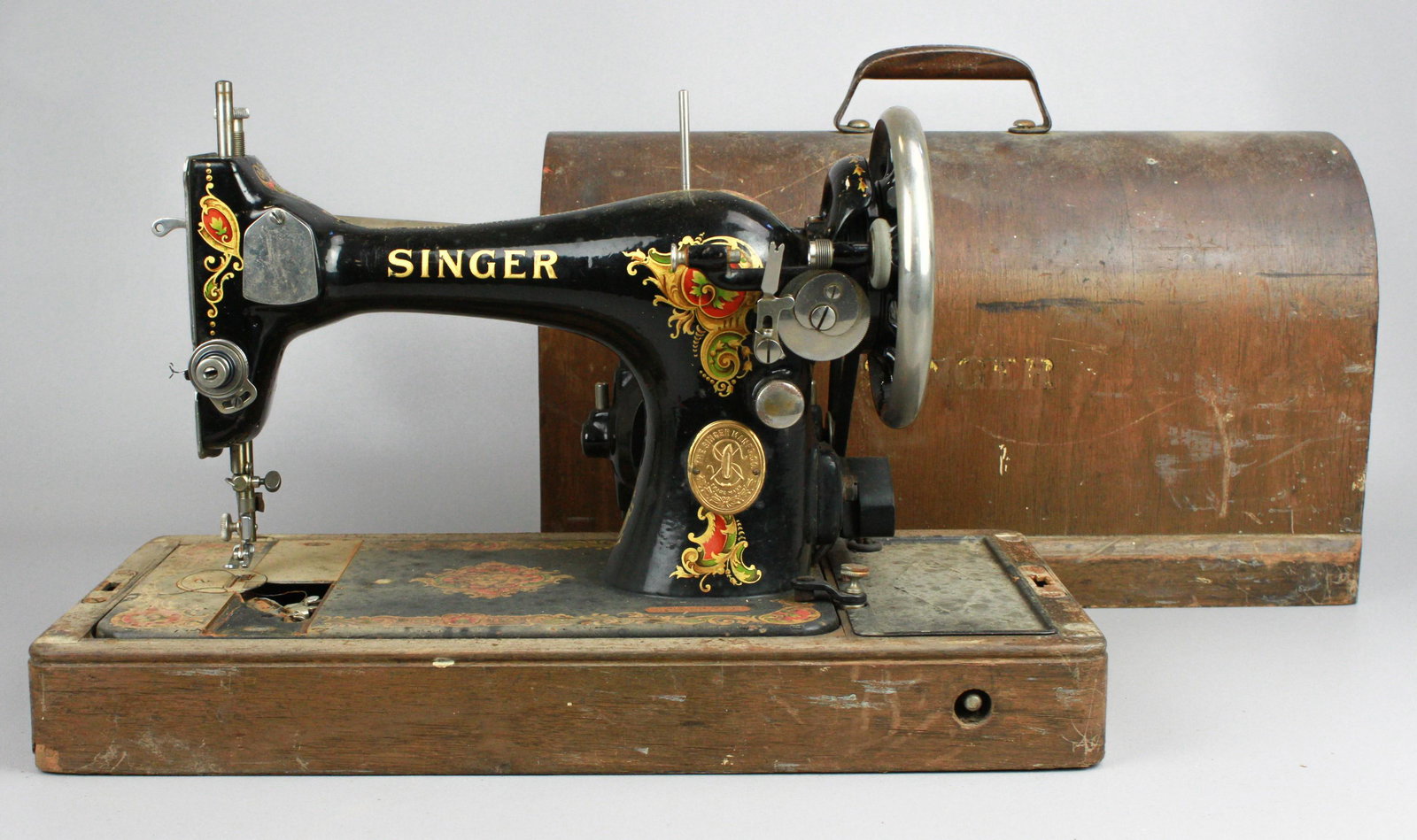 Portable Singer Sewing Machine: Portable singer sewing machine, gilt painted and etched body, 1928, B.U 7E Motor No. 4712106, in wood carrying case, case 15"h x 17-1/2"w x 7-3/4"d, some veneer damage