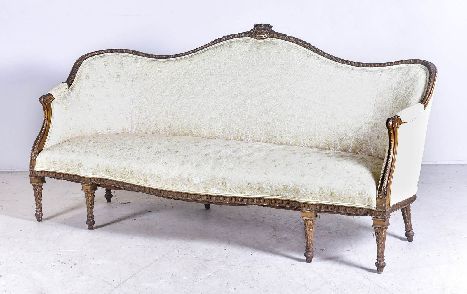 George III style gilt carved sofa, in the manner of: George III style gilt carved sofa, in the manner of Robert Adams, serpentine crest rail, floral upholstery, carved and gesso legs, 40"h x 82"w x 35-1/2"w