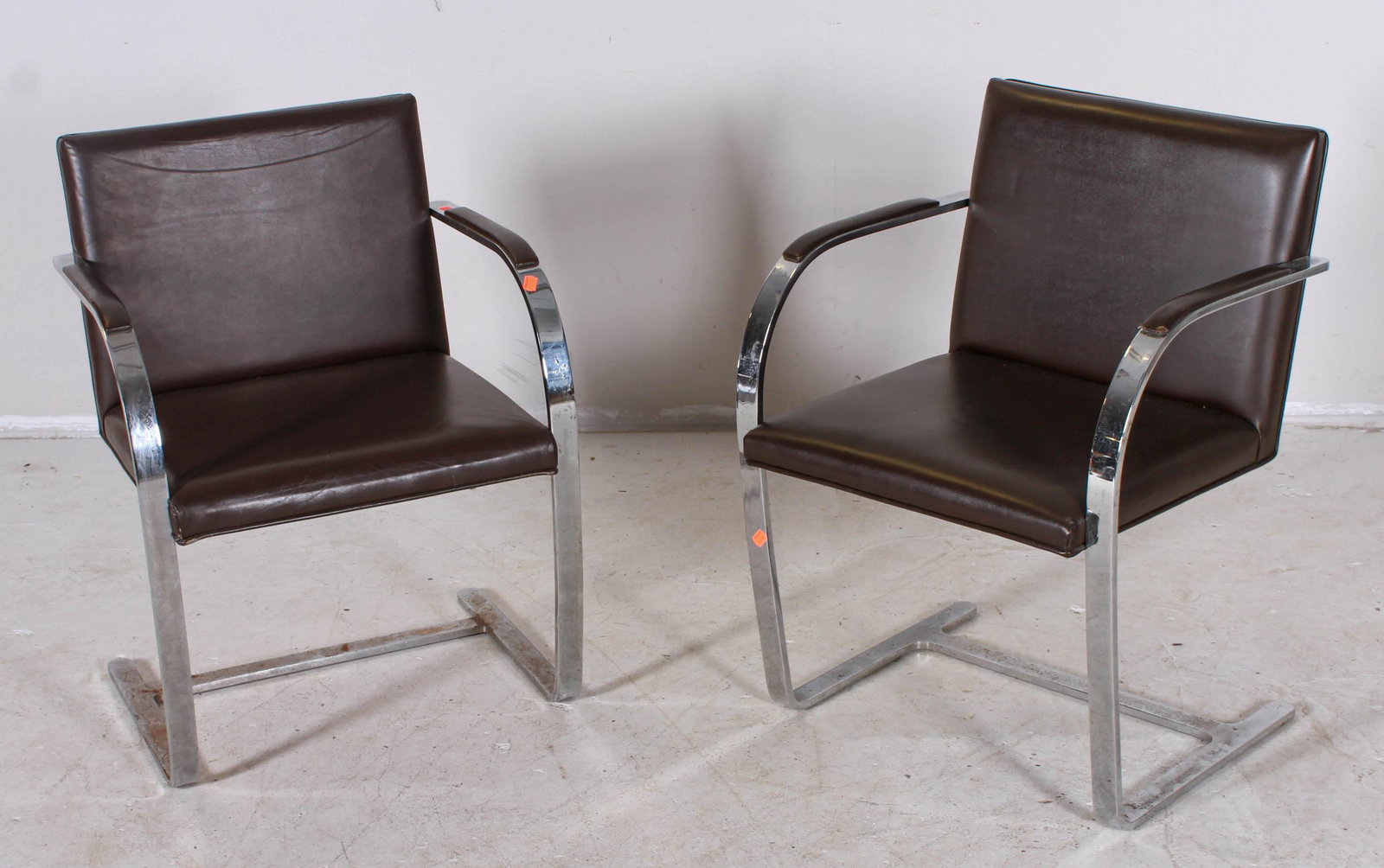 Pr stainless steel spring armchairs: Pr stainless steel spring armchairs in the manner of the Mies van der Rohe BRNO chair, unmarked, upholstered on brown leather, 32"h x 23"w x 18"d, light pitting to chrome