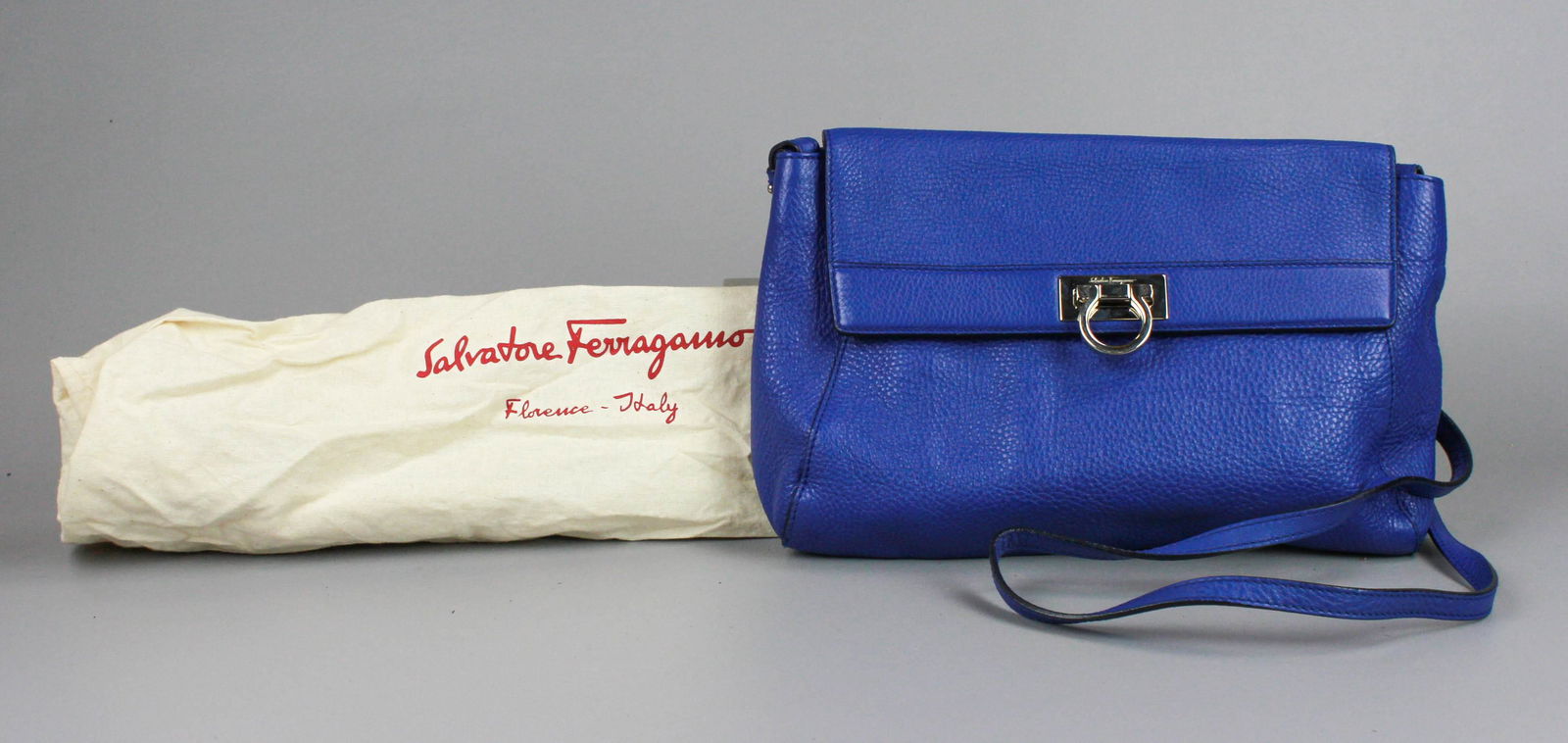 Salvatore Ferragamo Cobalt Leather Shoulder Bag: Salvatore Ferragamo cobalt leather shoulder bag, silvertone hardware, signature Ferragamo form closure with flap, adjustable strap, 12"Lx7-1/2"H, like new condition, includes original dust bag.