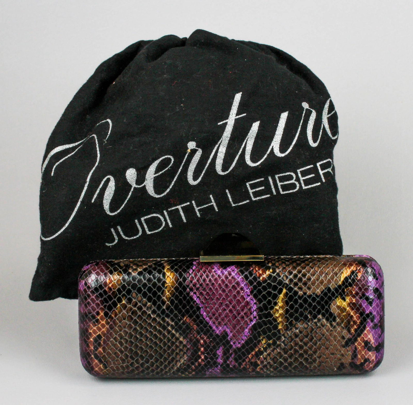 Judith Leiber Snakeskin Minaudiere: Judith Leiber Snakeskin Minaudiere, Overture, jewel tones, amethyst cut glass cabochon closure, gold tone raised, 8-3/4"Lx3-1/2"H, excellent condition, original dust bag.