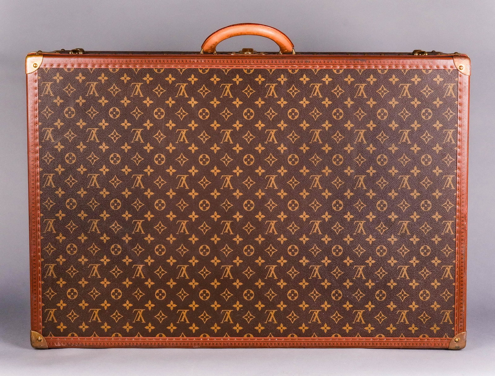 Louis Vuitton Alzer Rigid Suitcase: Louis Vuitton Alzer monogrammed rigid suitcase, classic suitcase shape, removable interior tray, "EJK" mono, corners with brass reinforcements, leather handle, lock with 2 keys, serial number 985318, 