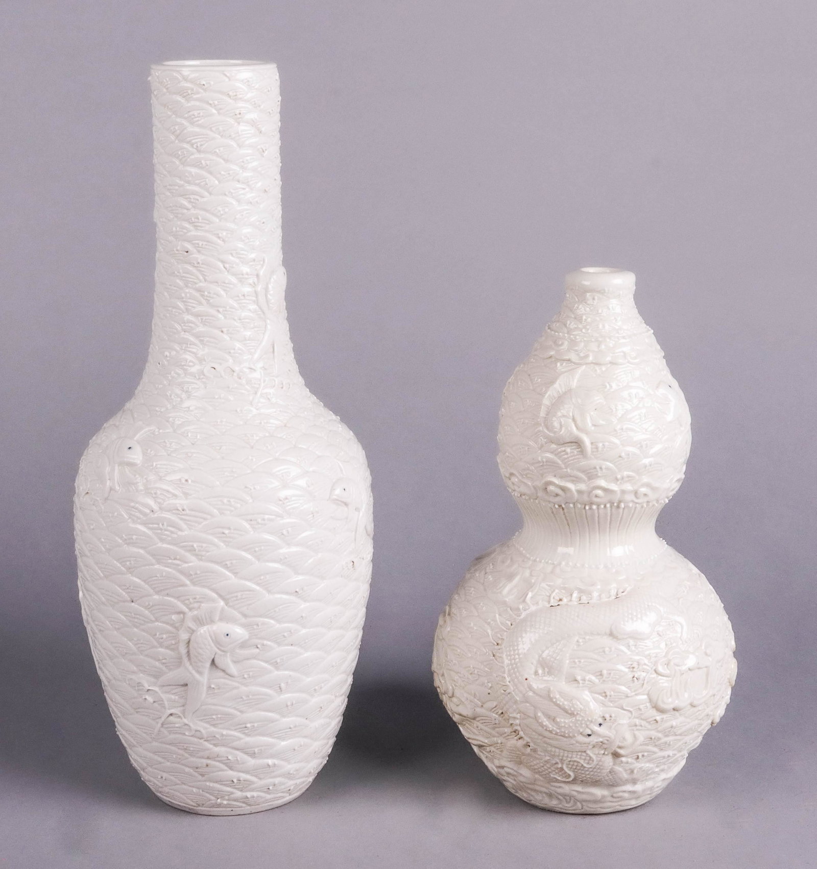 (2) Wang Bingrong Vases: (2) Chinese carved porcelain vases, cream glazed, each bearing mark of Wang Bingrong, c/o 11-5/8" bottle vase with fish & waves design, 8-1/2" double gourd vase with fish & dragon in waves design, ver
