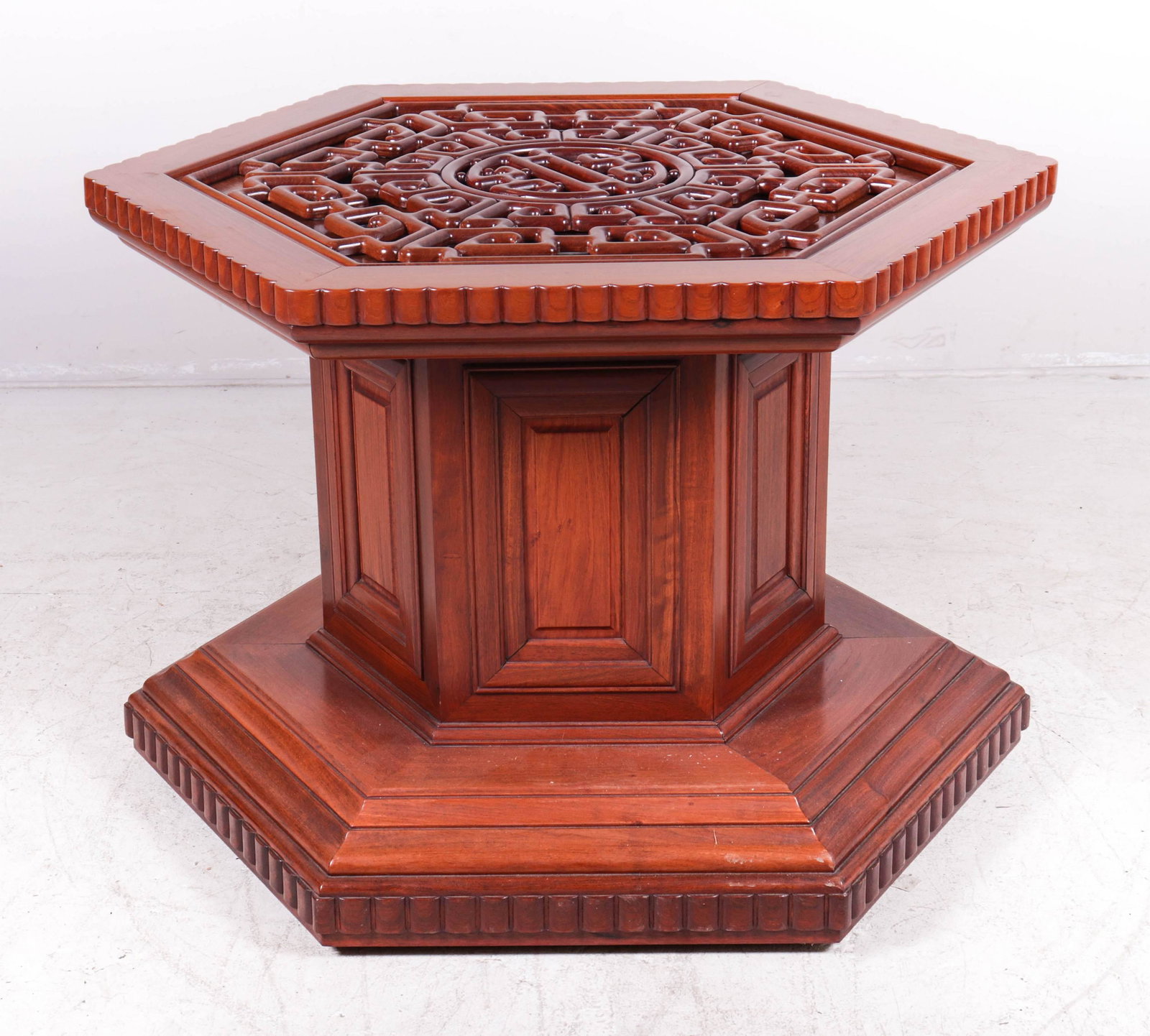 Rosewood paneled octagonal center table: Rosewood paneled octagonal center table, ribbon edge top and around bottom base, applied pierced carving, 33"h x 40"diameter, missing glass
