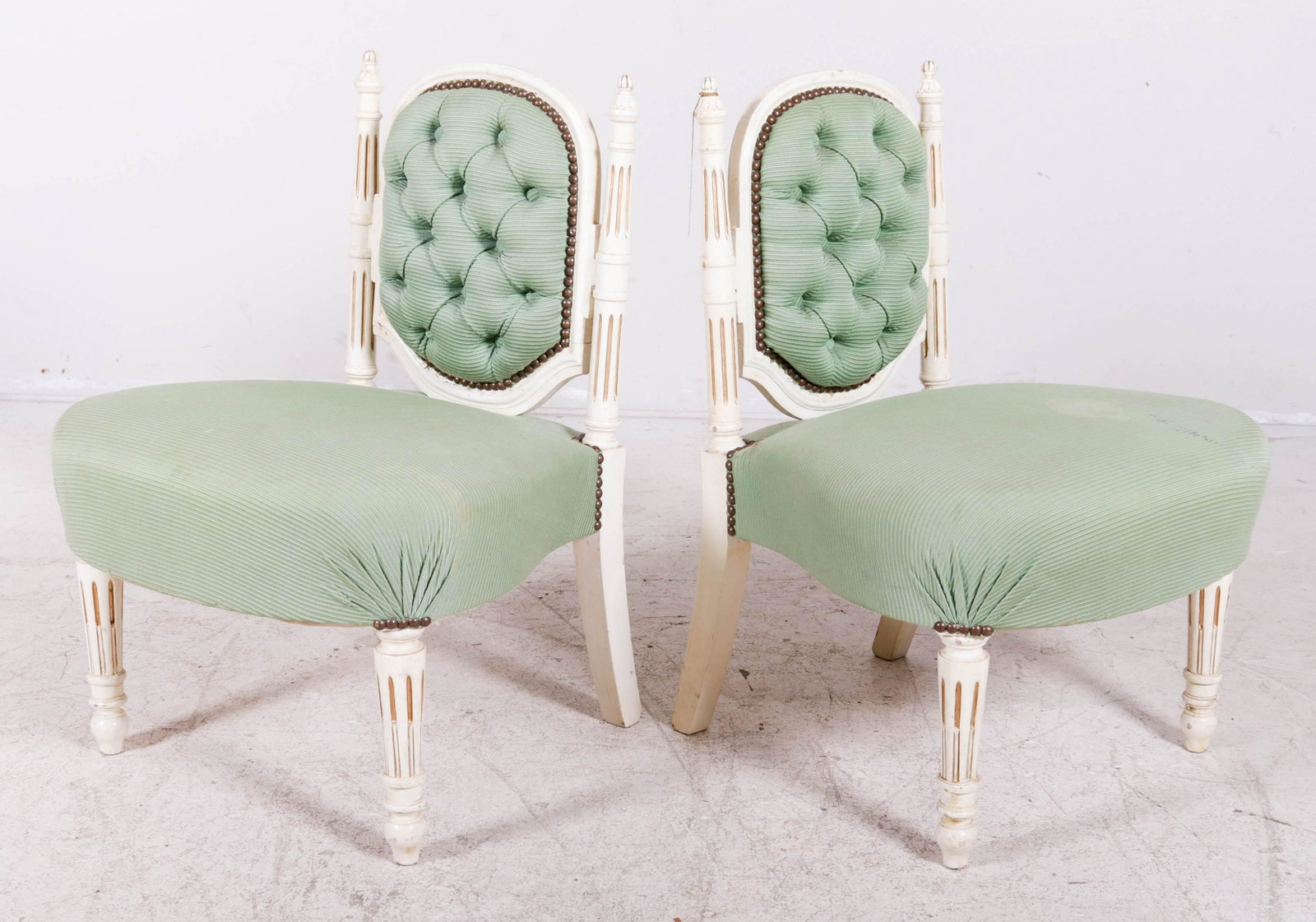 Pr Louis XVI style cream painted and gilt slipper: Pair Louis XVI style cream painted and gilt slipper chairs, green upholstery, 28"h x 21"w x 23"d, soiling to upholstery, Yes, it has been recovered. Light wear to paint, soiling to upholstery.