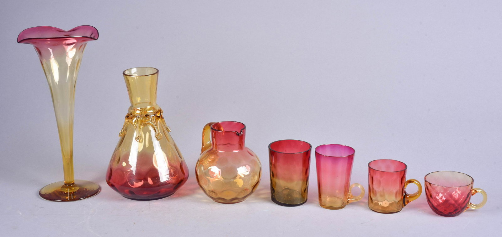 (7) Amberina Glasses, Vases and Pitcher: (7) Amberina glasses, vases and pitcher to include child's mug with applied handle, diamond patterned punch cup, tumbler, 3-/4"h, low handled lemonade mug, thumbprint pitcher, amber applied claw handl