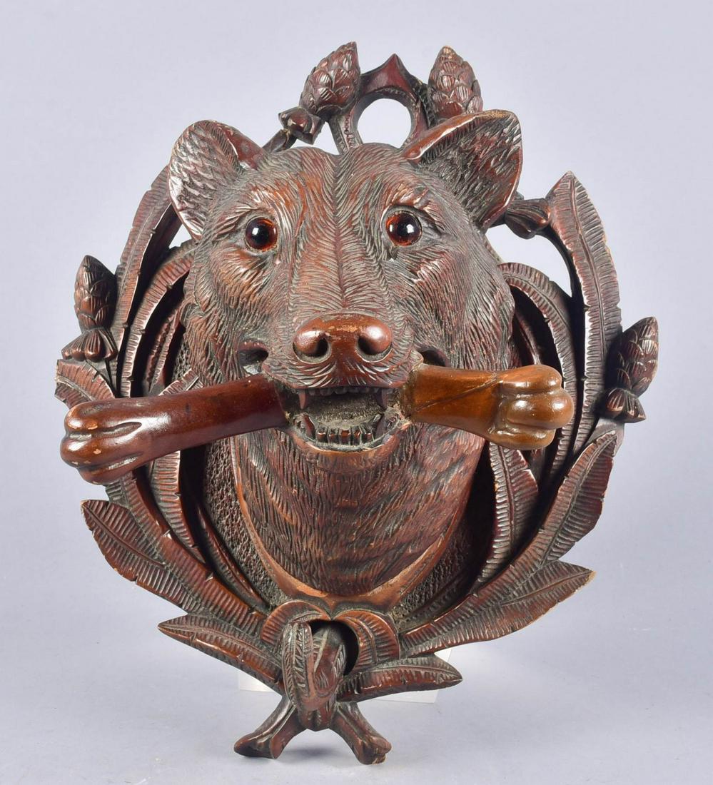 Black Forest Carved Wolf Coat Hook: Black forest carved wall hanging coat hook, wolf head holding bone in mouth, single hook 13-1/4" h x 11" w, one broken leaf, crack in the back of the wolf coat hook