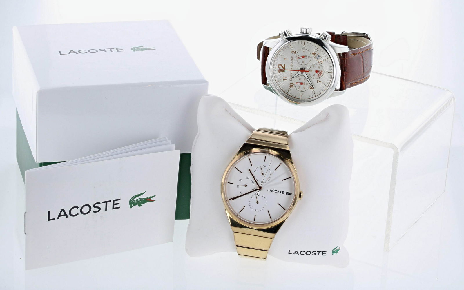 Dooney & Bourke and Lacoste Watches: A Dooney & Bourke SS round dial watch w/red and white hands, and a Gold tone Lacoste watch in its org. box. Both watches in good condition with light wear, new batteries 5/1/2021, keeping time, no war