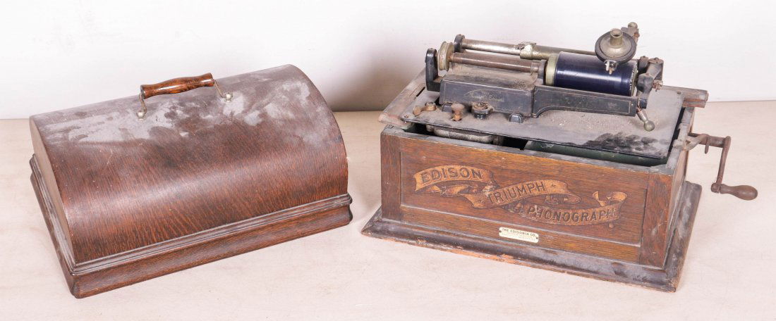 Edison Triumph cylinder phonograph: Edison Triumph cylinder phonograph, frame of inside lid needs to be rebuilt, with crank and reproducer, lacking horn, with retailers tag of the Edisonia Co, Newark, NJ